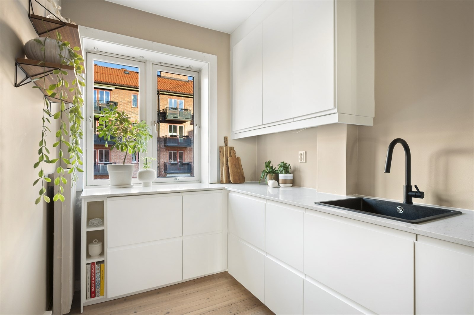 Tidsriktig innredning med hvite, glatte fronter og benkeplate i komposittstein. Galleribilde