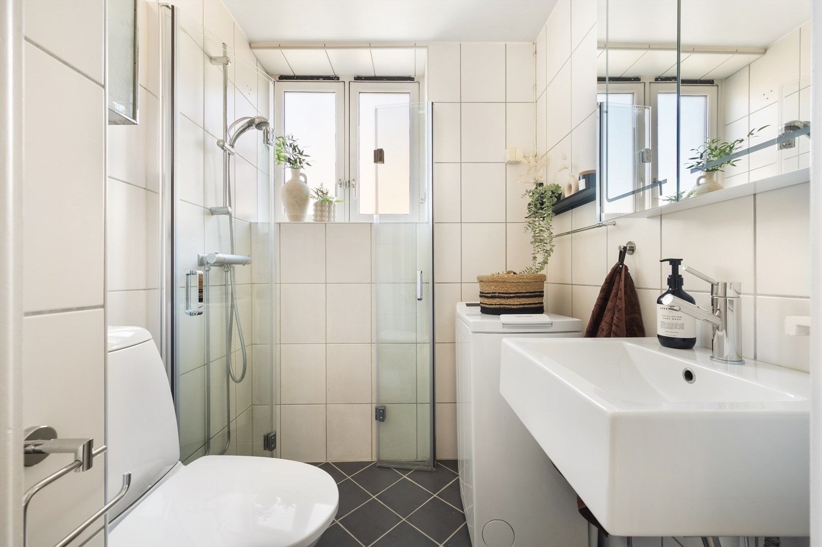 Tidløst og funksjonelt bad fra 2004 med flislagte overflater, elektrisk gulvvarme og innfelte downlights i himling. Det er opplegg for vaskemaskin. Galleribilde