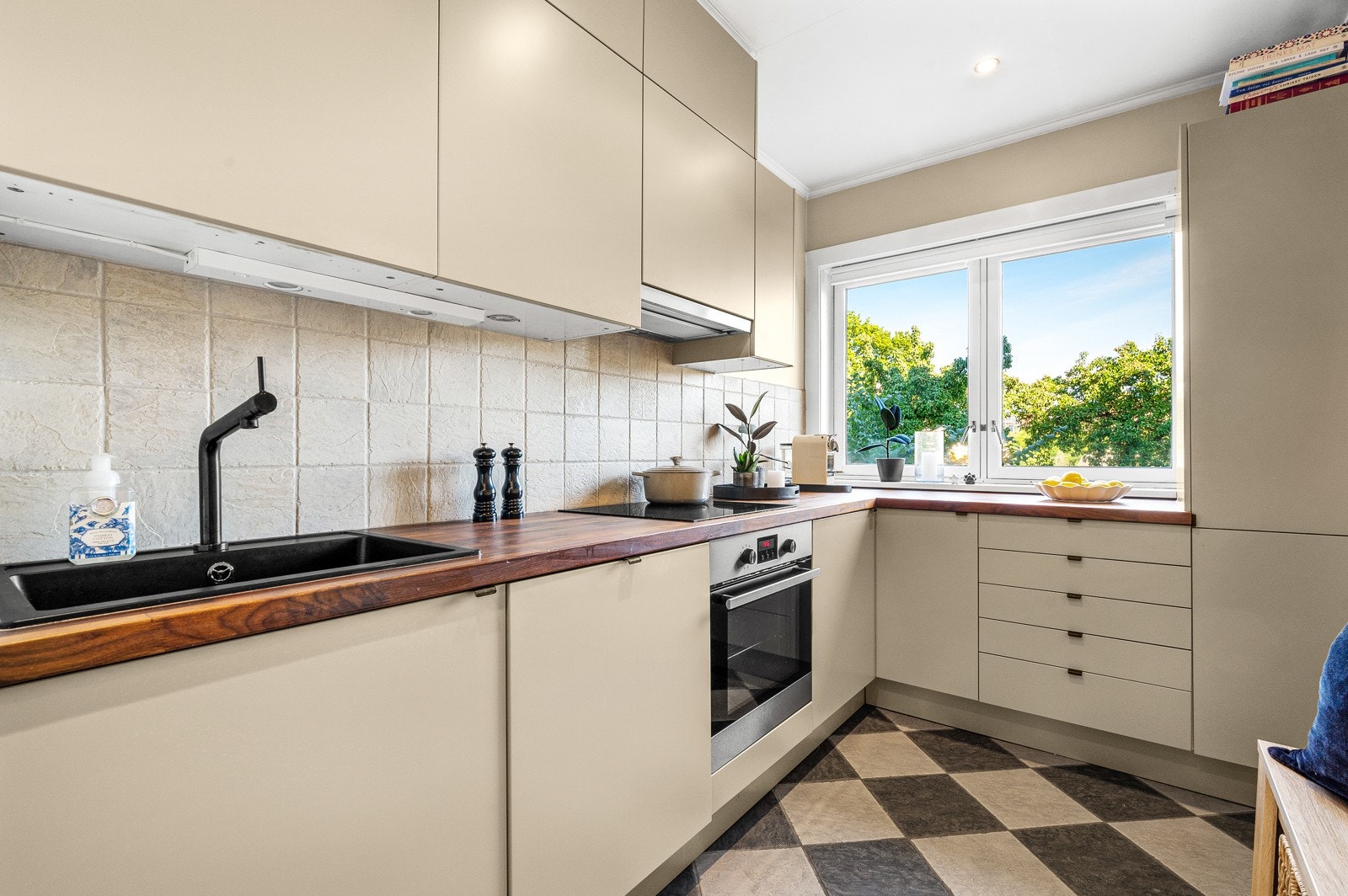 Kjøkkeninnredning av slette fronter fra epoq, benkeplate av tre og benkeskapsbelysning under overskap. Galleribilde