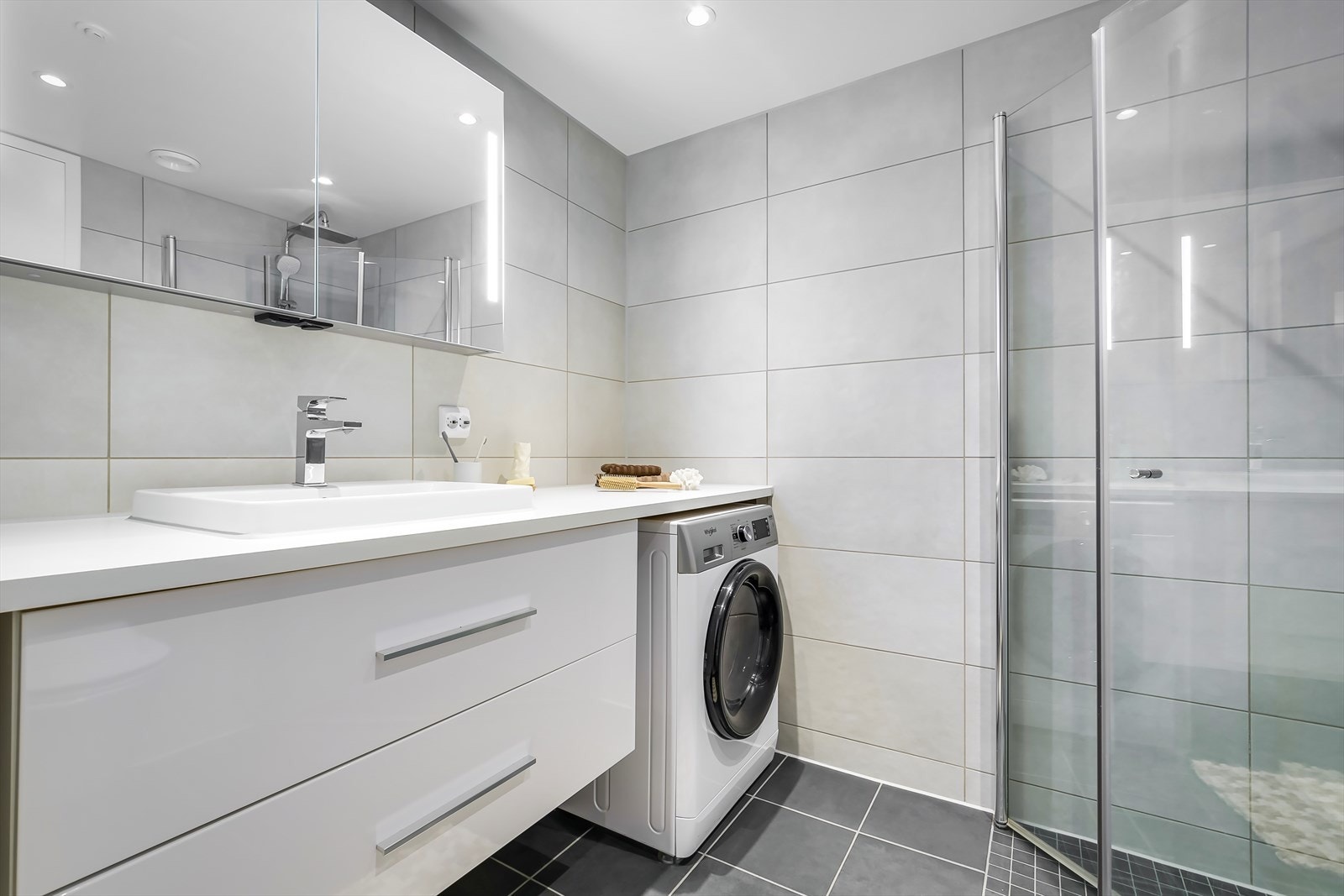 Innbydende, flislagt bad i en tidsnøytral utførelse. Badet er oppført som et prefabrikkert modulbad, og det er vannbåren varme i gulv. Galleribilde