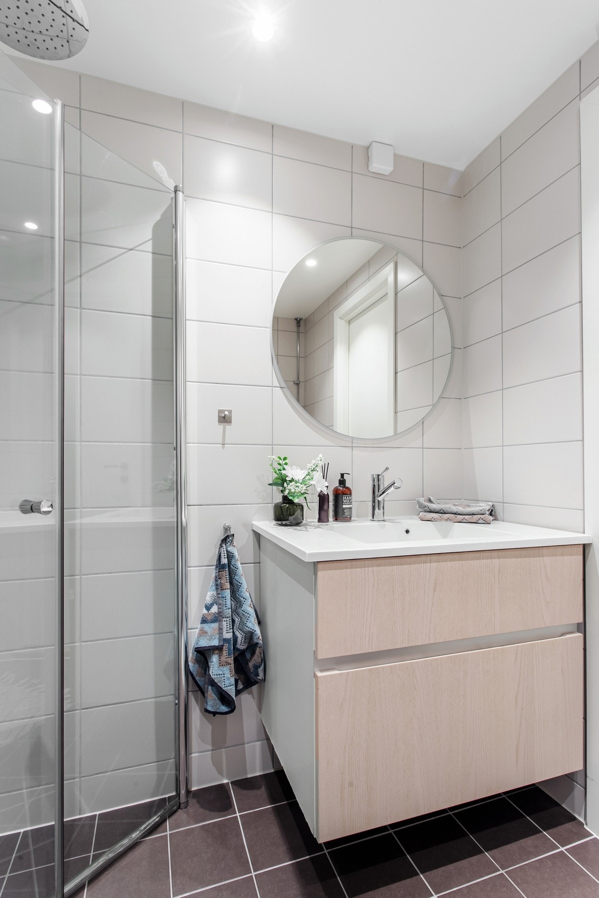Badet er utstyrt med servantskap med speil over, vegghengt wc, dusjhjørne med regnfallsdusj, og opplegg for vaskemaskin Galleribilde