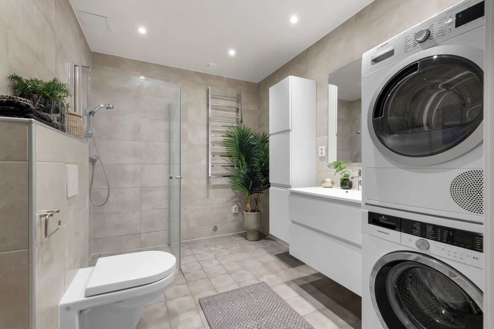 Baderommet er moderne og stilrent, med delikate fliser og elektriske varmekabler for ekstra komfort. Galleribilde