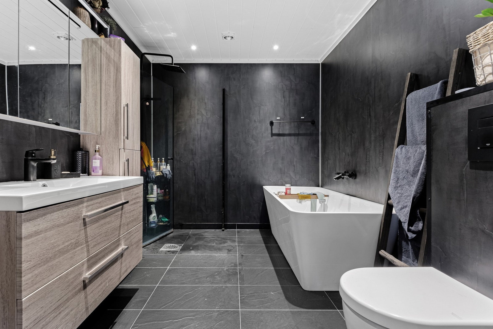 Stilrent bad fra 2022 med moderne fliser, varme i gulvet og downlights i taket. Galleribilde