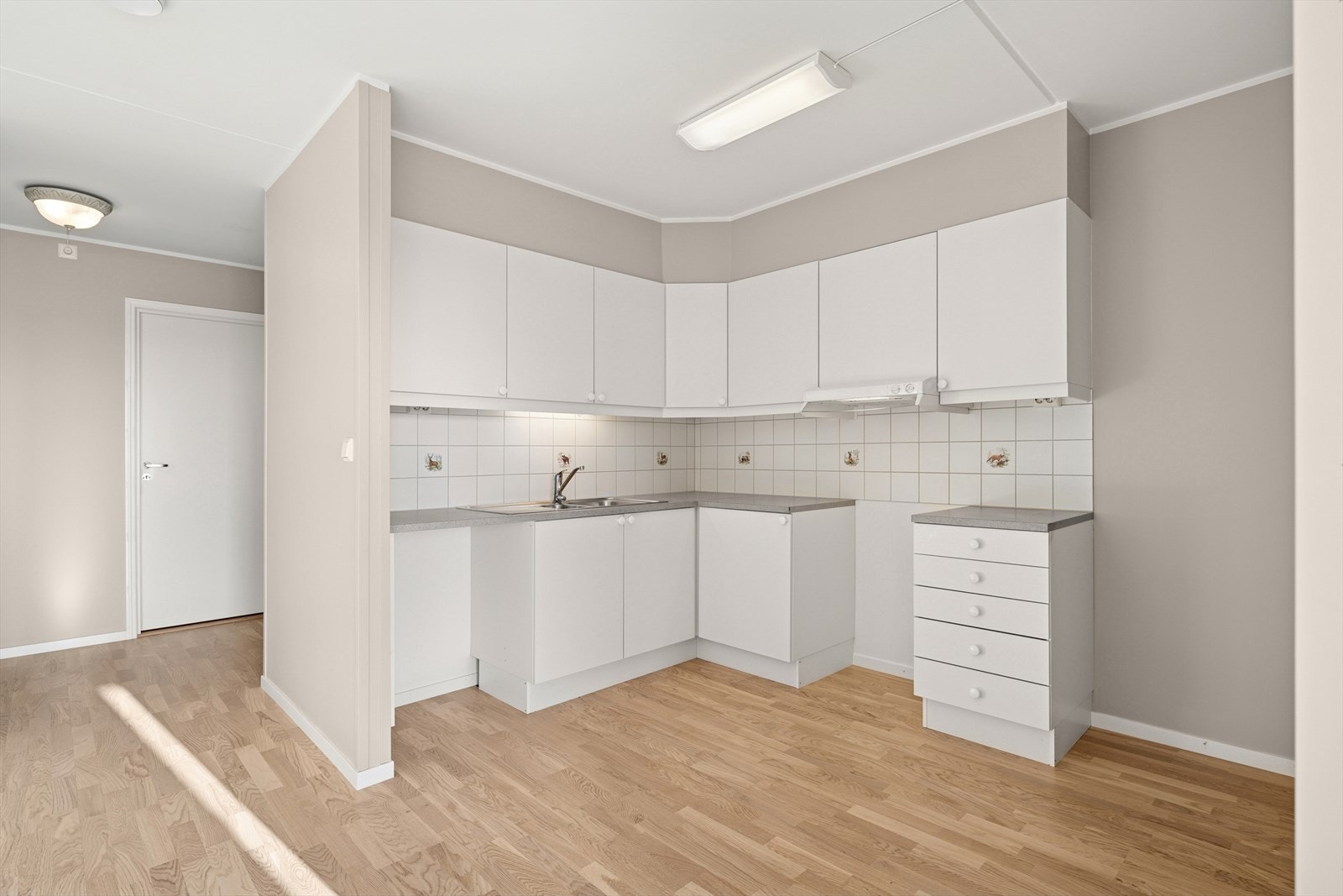 Kjøkkeninnredning utført med glatte fronter og laminat benkeplate med nedfelt kum og 1-greps blandebatteri. Galleribilde