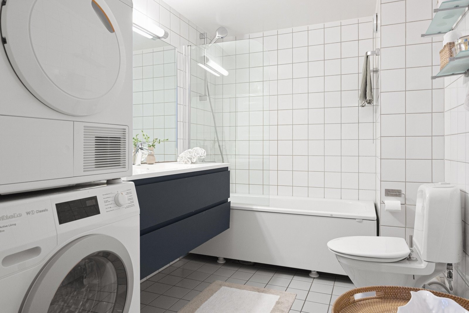 Stort, flislagt bad med varmekabler i gulv og lampe i himling Galleribilde