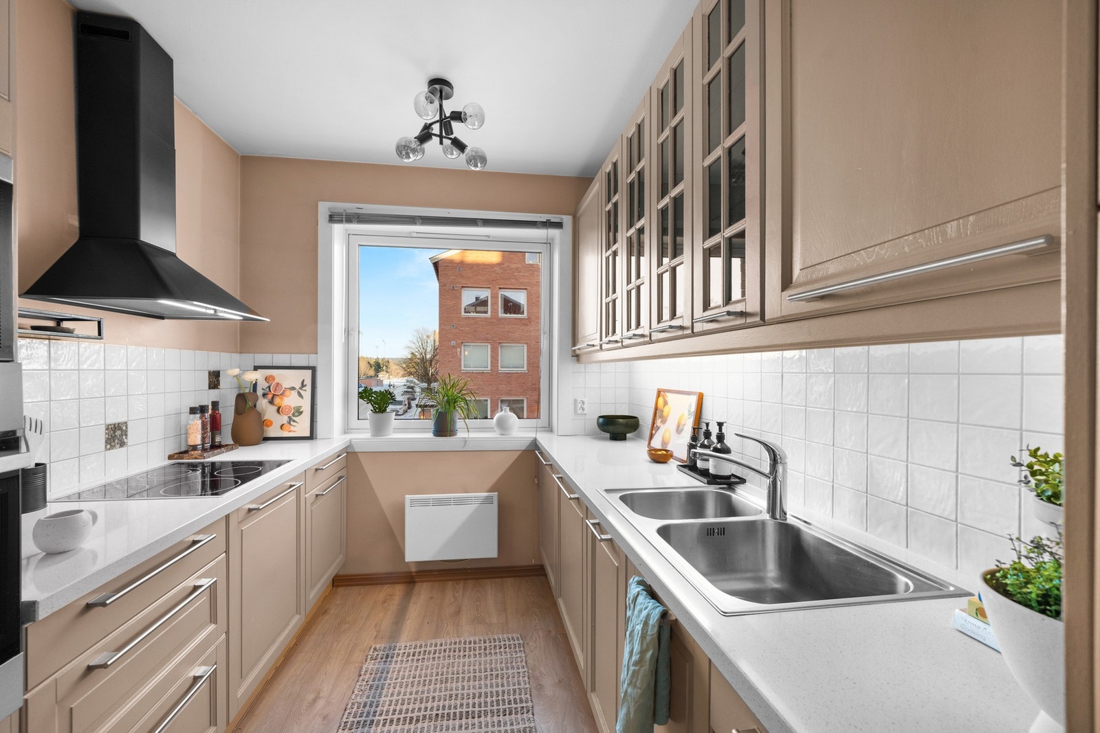 Det separate kjøkkenet har en gjennomført og elegant stil med beige innredning, speilfronter og vitrinefronter som gir et lekkert preg. Galleribilde