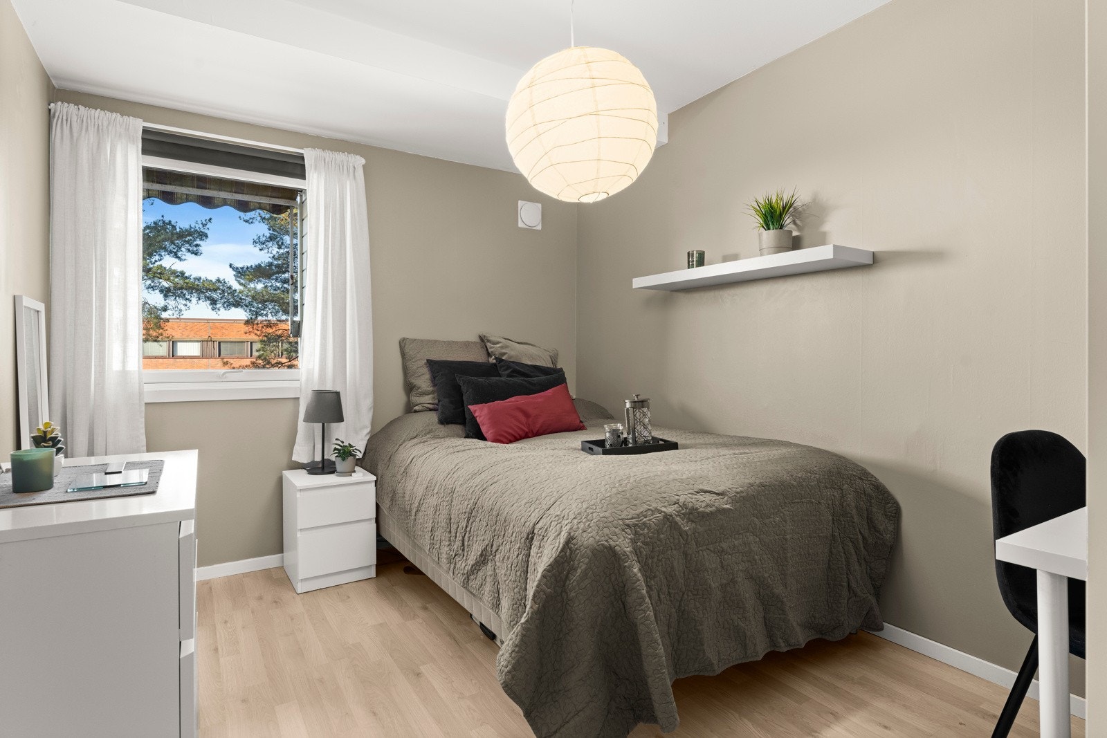 Leiligheten har et romslig og lyst soverom med laminatgulv og nøytrale, lysmalte vegger. Galleribilde