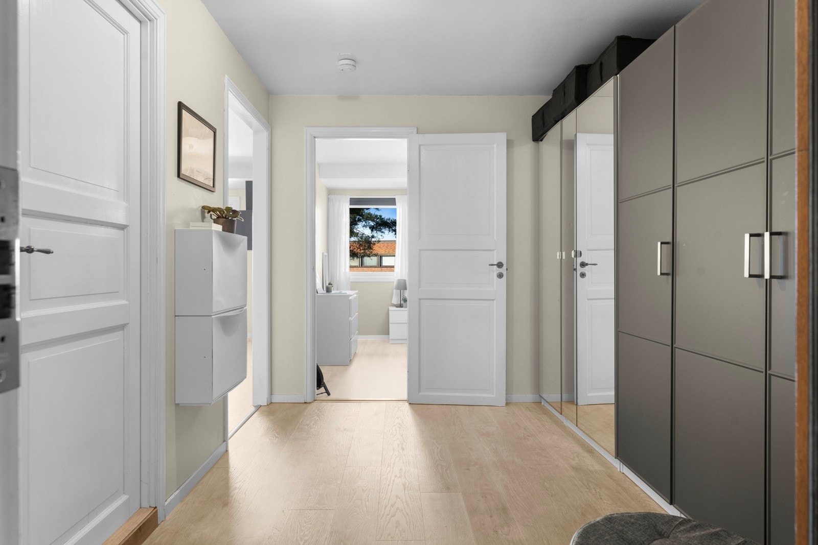 Her finner du en romslig garderobe med rikelig plass til oppbevaring av yttertøy og sko - en praktisk løsning som holder gangen ryddig. Galleribilde