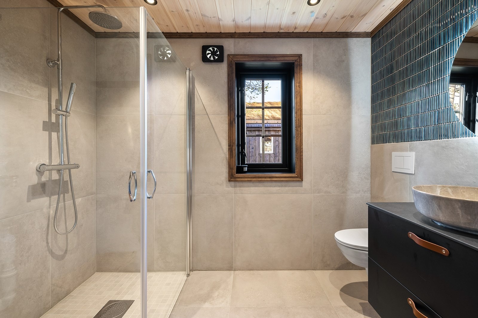 Romslig bad som er helfliset og med reinfallsdusj Galleribilde