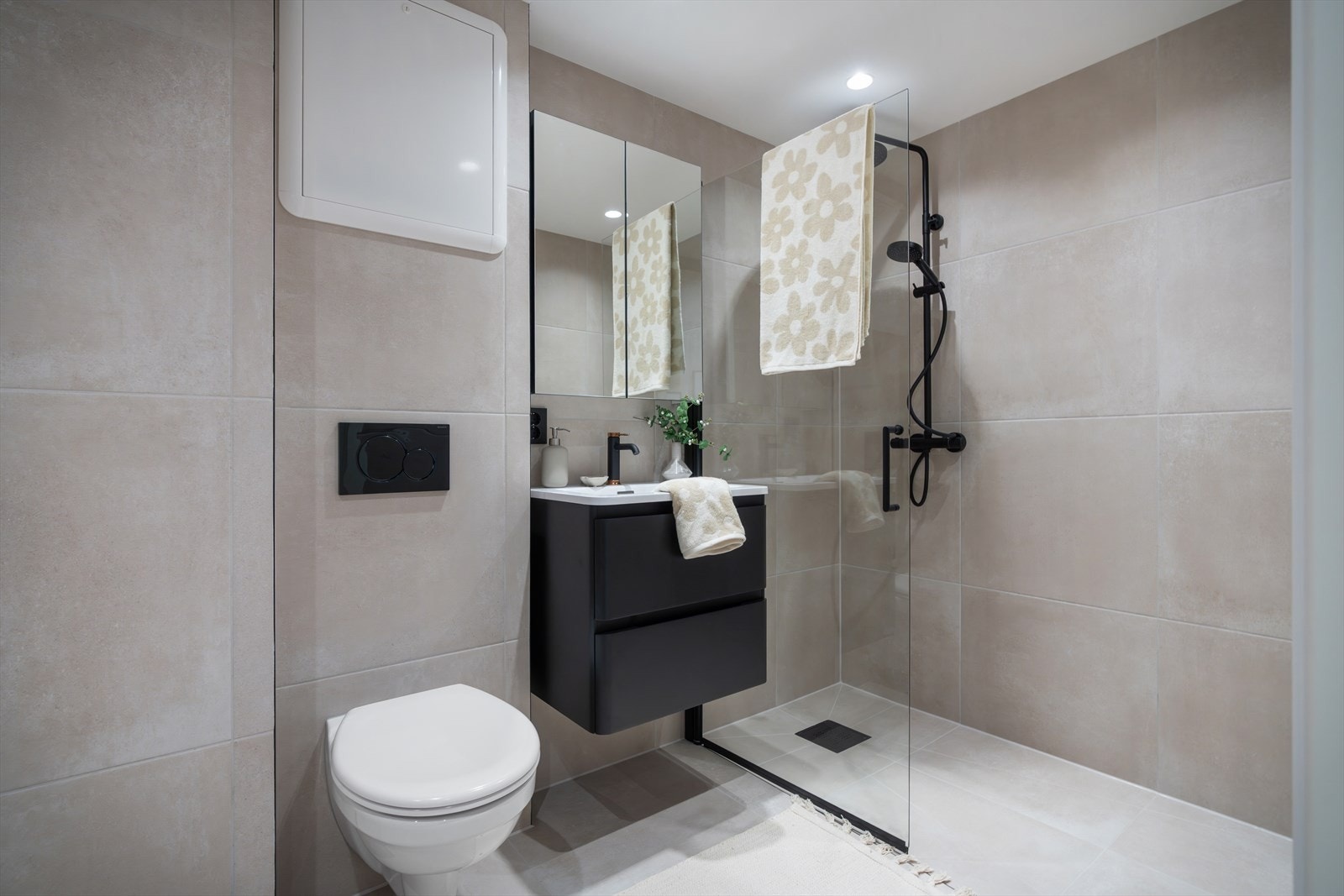 - Innredet med vegghengt toalett, servantmøbel, speilskap og dusjhjørne med glassdør - Galleribilde