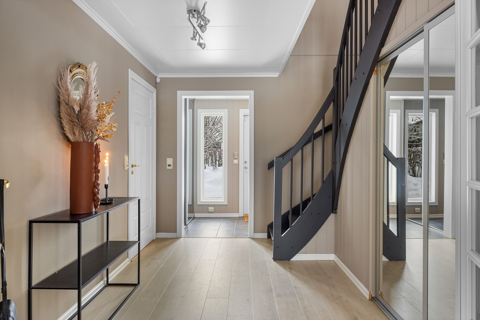 Når du entrer boligen kommer du inn i en praktisk entré med flislagt gulv, stor skyvedørsgarderobe og adkomst til toalettrom. Videre kommer du inn i en romslig gang. Det er gulvvarme i både entréen og gangen. Galleribilde