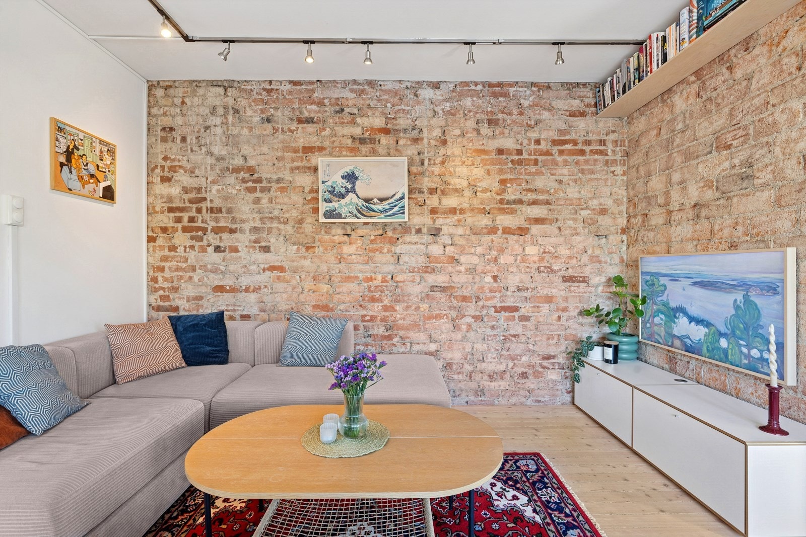Stuen har en markant teglsteinsvegg som gir et romslig og vakkert preg Galleribilde
