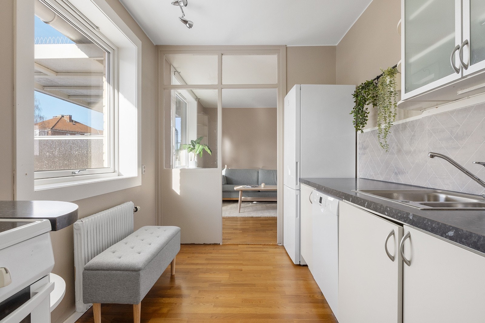 Kjøkkeninnredning med glatte laminerte skapfronter, laminert benkeplate med sprutplate på bakvegg, 1 1/2 oppvaskkum, ventilator og frittstående hvitevarer som komfyr, oppvaskmaskin, kjøl/- fryseskap. Det er avtrekk over kokesone via kjøkkenventilator med Galleribilde