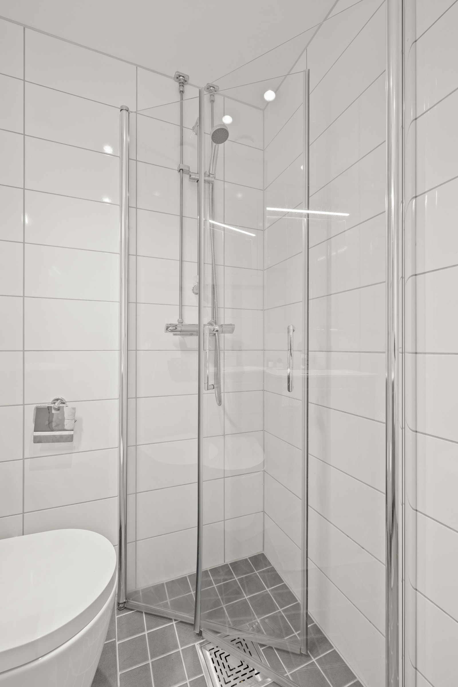 Badet har varmekabler i gulv, opplegg for vaskemaskin samt dusjhjørne med innfellbare dører. Galleribilde