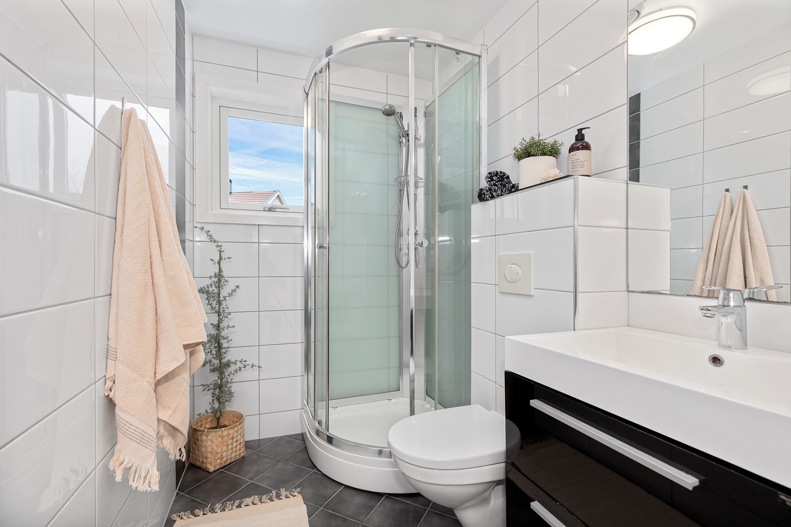 Baderom fra byggeår 2012 innredet med dusjkabinett, servant og vegghengt toalett. Galleribilde