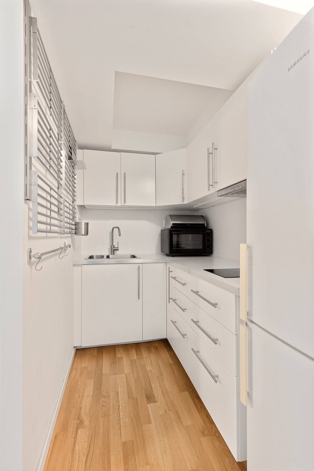 Hybelkjøkken med glatte fronter, laminat benkeplate med vask og platetopp med 2 kokesoner. Galleribilde