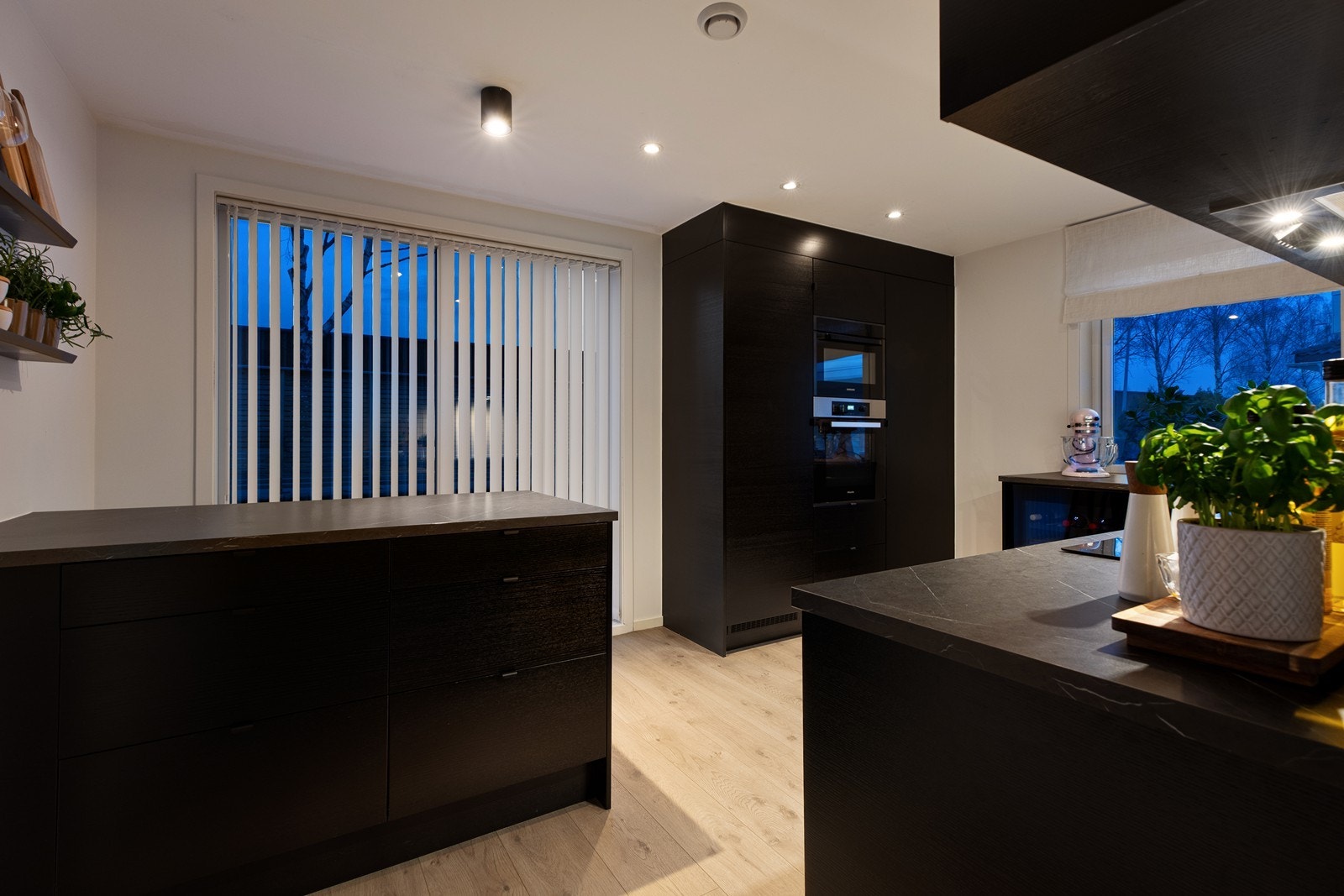 Stilrent kjøkken med slette fronter og laminat benkeplate med vask. Galleribilde