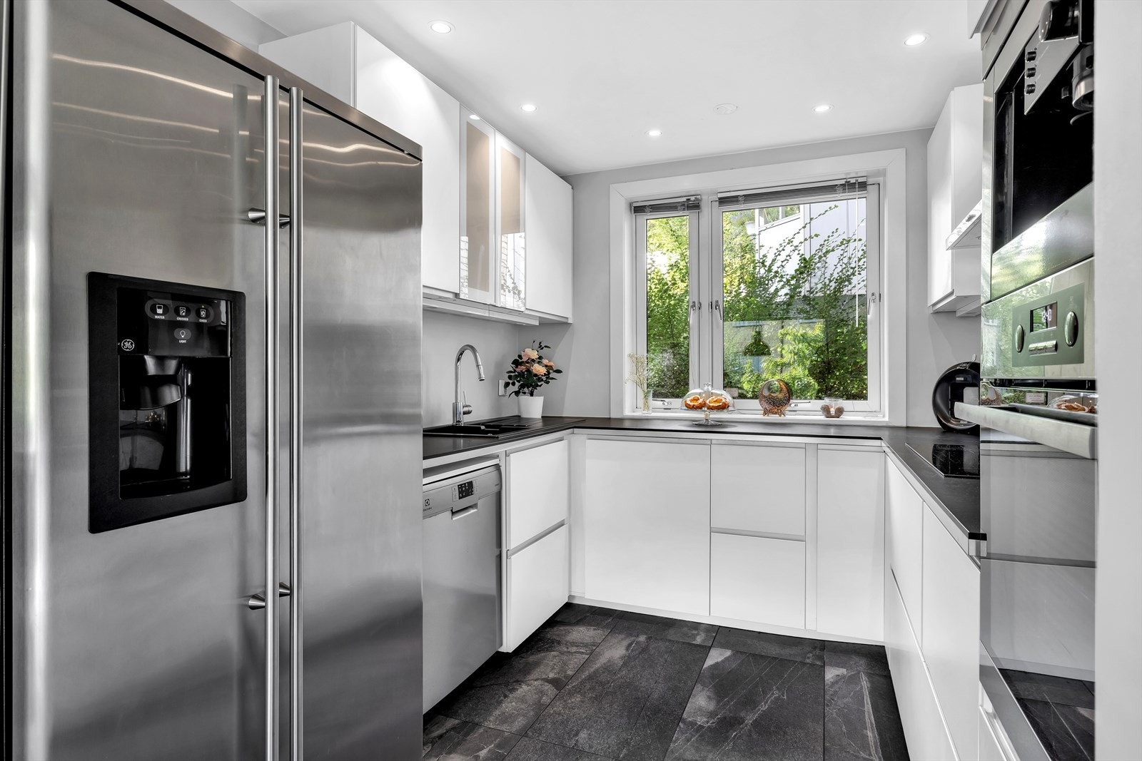 Frittstående side-by-side kjøl og frys, samt oppvaskmaskin, resten av hvitevarene er integrerte Galleribilde