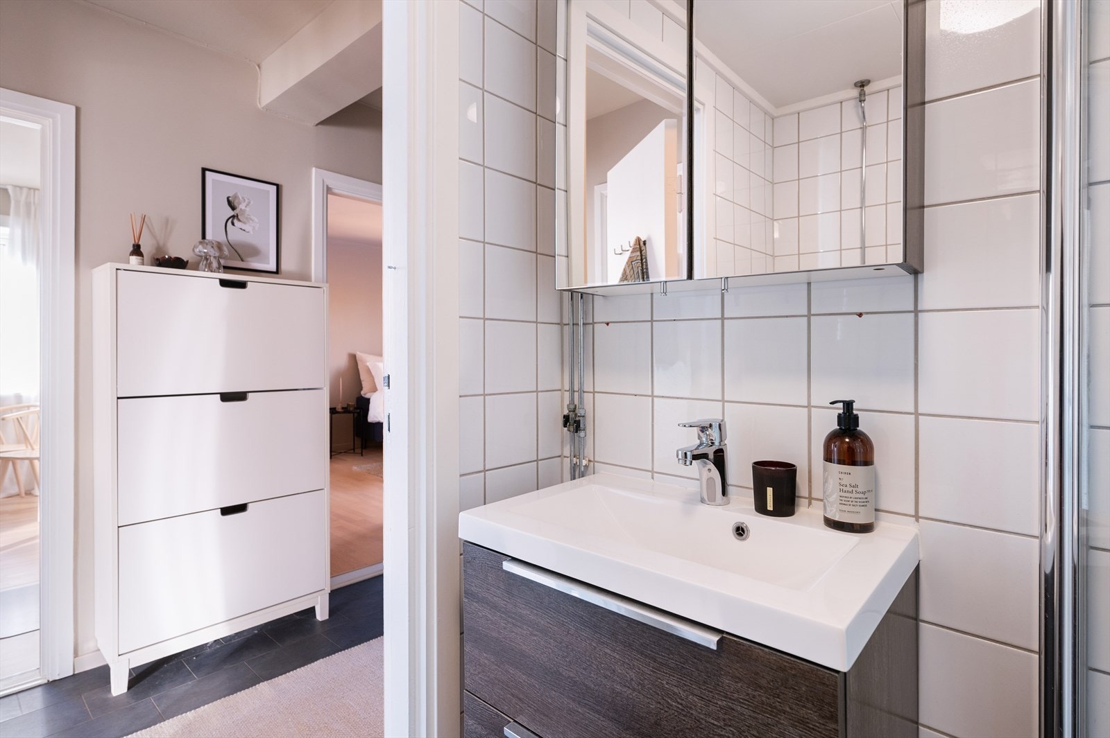 Badet er innredet med vegghengt speilskap, servant med underskap, klosett og dusjhjørne med svingbare glassdører. Galleribilde