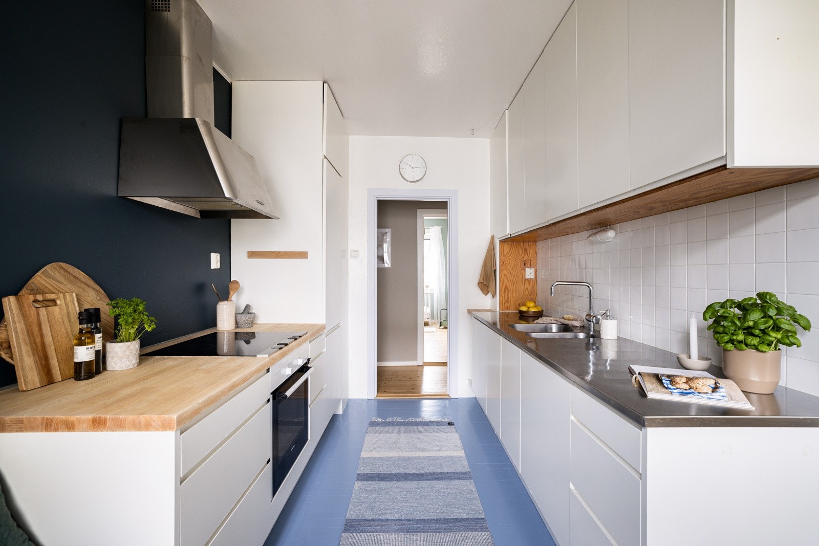 Du har god skap- og benkeplass i innredningen som har hvite glatte fronter og benkeplate av heltre på den ene siden og oppvaskbenk i børstet stål på den andre siden. Galleribilde