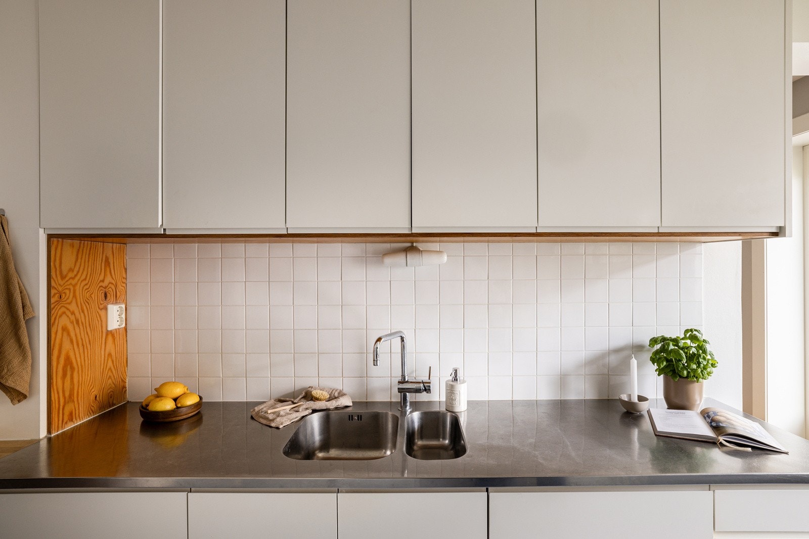 Både fint og praktisk med dekorative fliser i benkeryggen og belysning under overskapene. Galleribilde