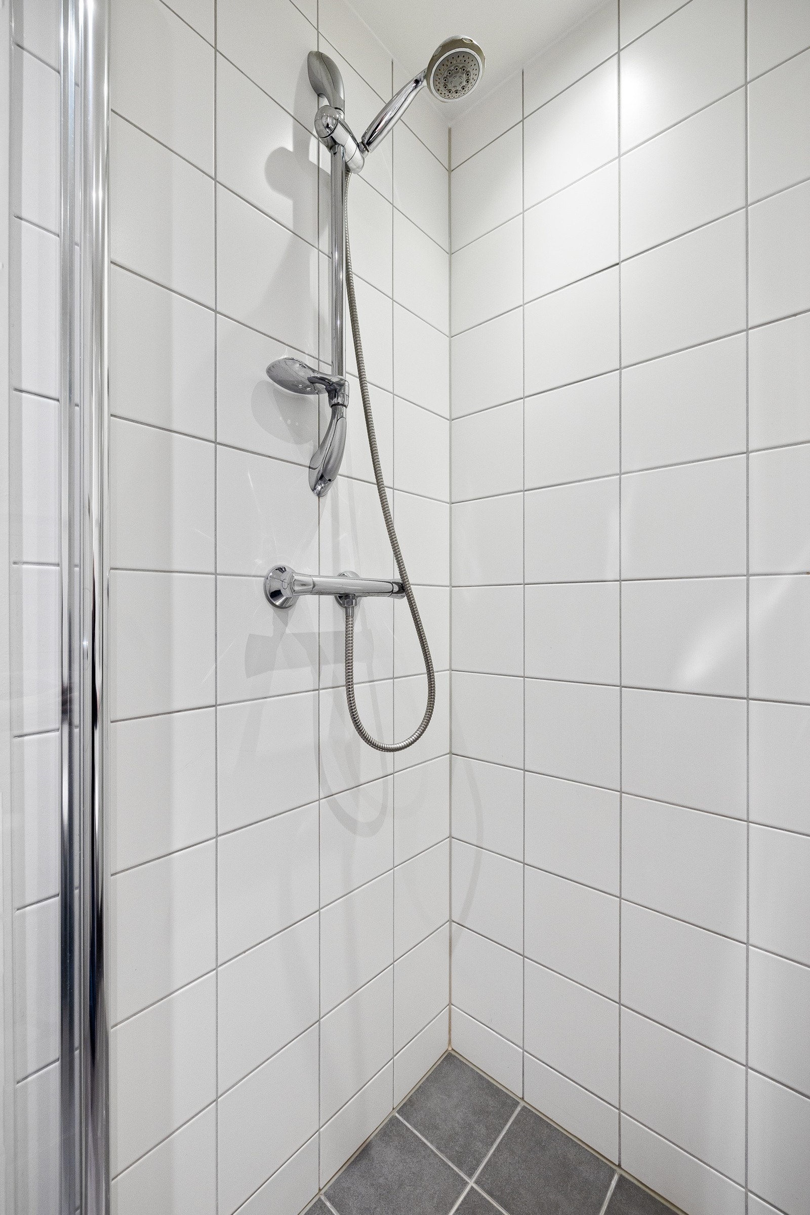 Dusjhjørne med glassvegger og gulvmontert vegghengt toalett. Opplegg/plass til vaskemaskin. Galleribilde