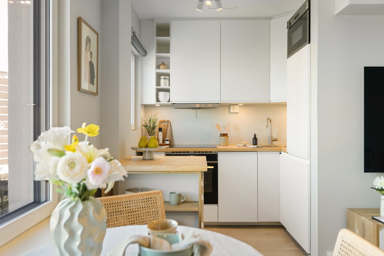 Moderne IKEA-kjøkkeninnredning fra 2021 med slette fronter, benkeplate av av typen PINNARP fra IKEA som er mindre sensitiv for fukt og kan pusses ned og overflatebehandles ved behov, oppvaskkum og kjøkkenventilator i stål med kanal til yttervegg. Galleribilde