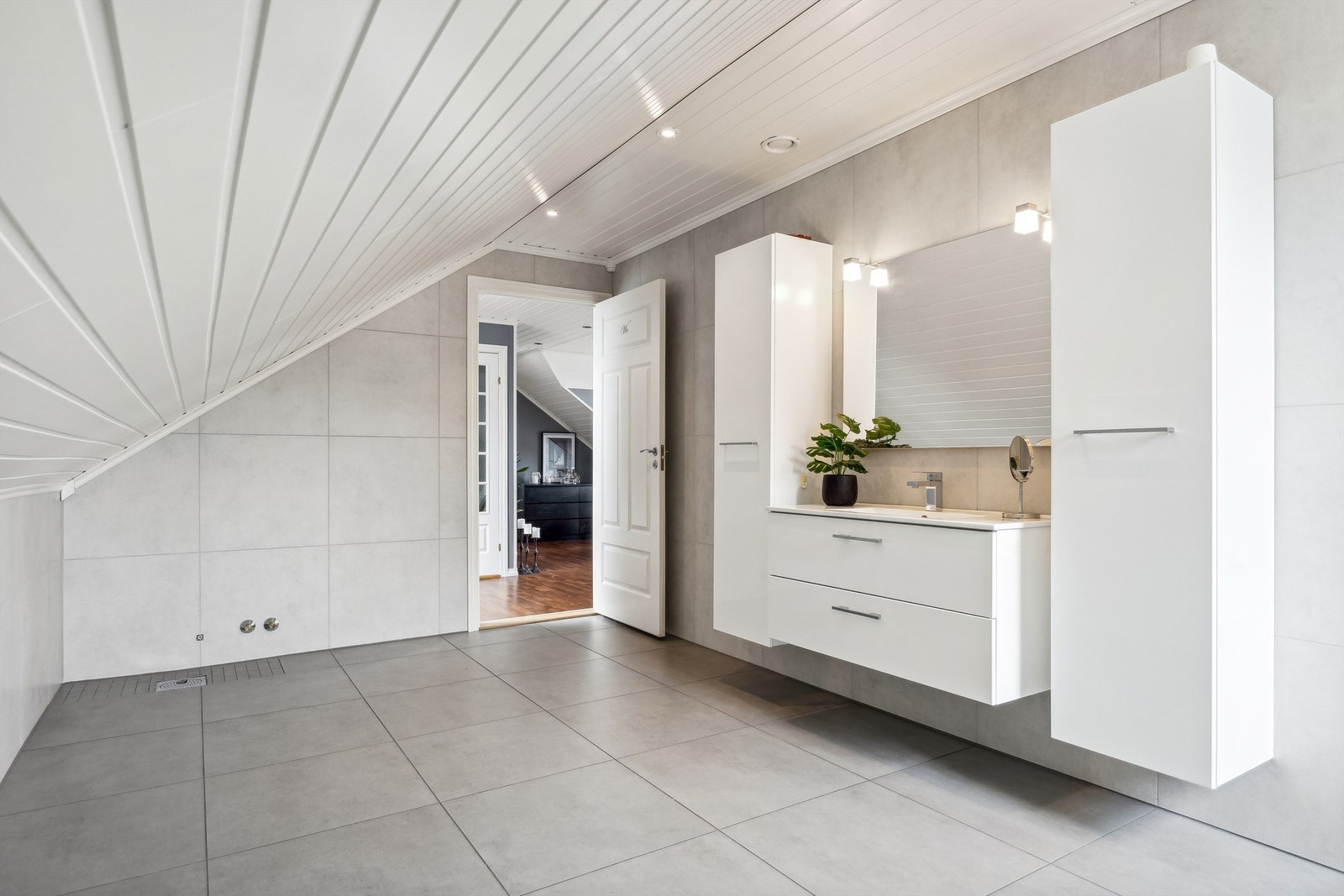 Lekkert bad i loftstetasjen. Badet er innredet med servantinnredning med skuffer, vegghengt baderomsmøbler med dører og gulvstående toalett. Opplegg for badekar. Galleribilde