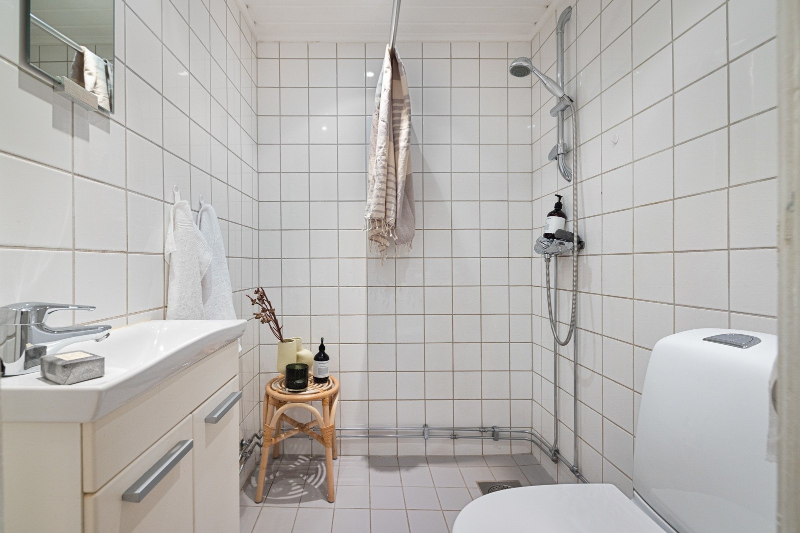 Baderommet inneholder dusjnisje, servantskap, speil, samt gulvstående klosett. Galleribilde