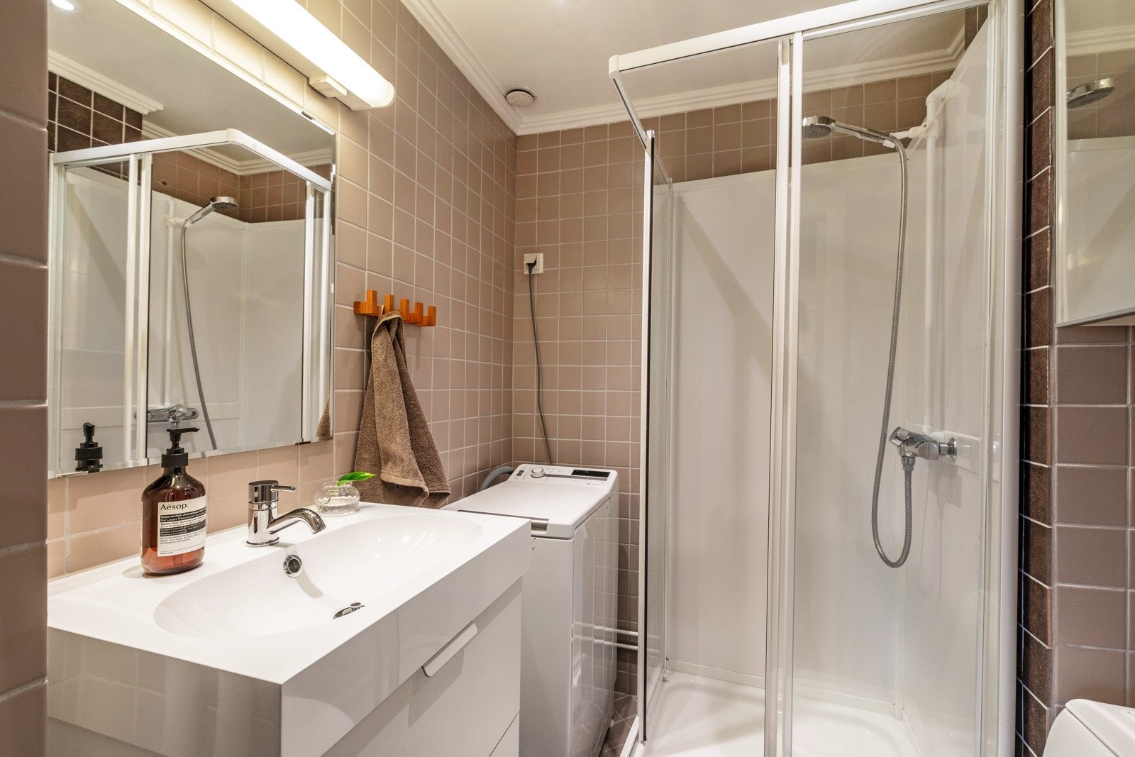 Badet er utstyrt med dusjkabinett, stående toalett, servant med underskap. Galleribilde