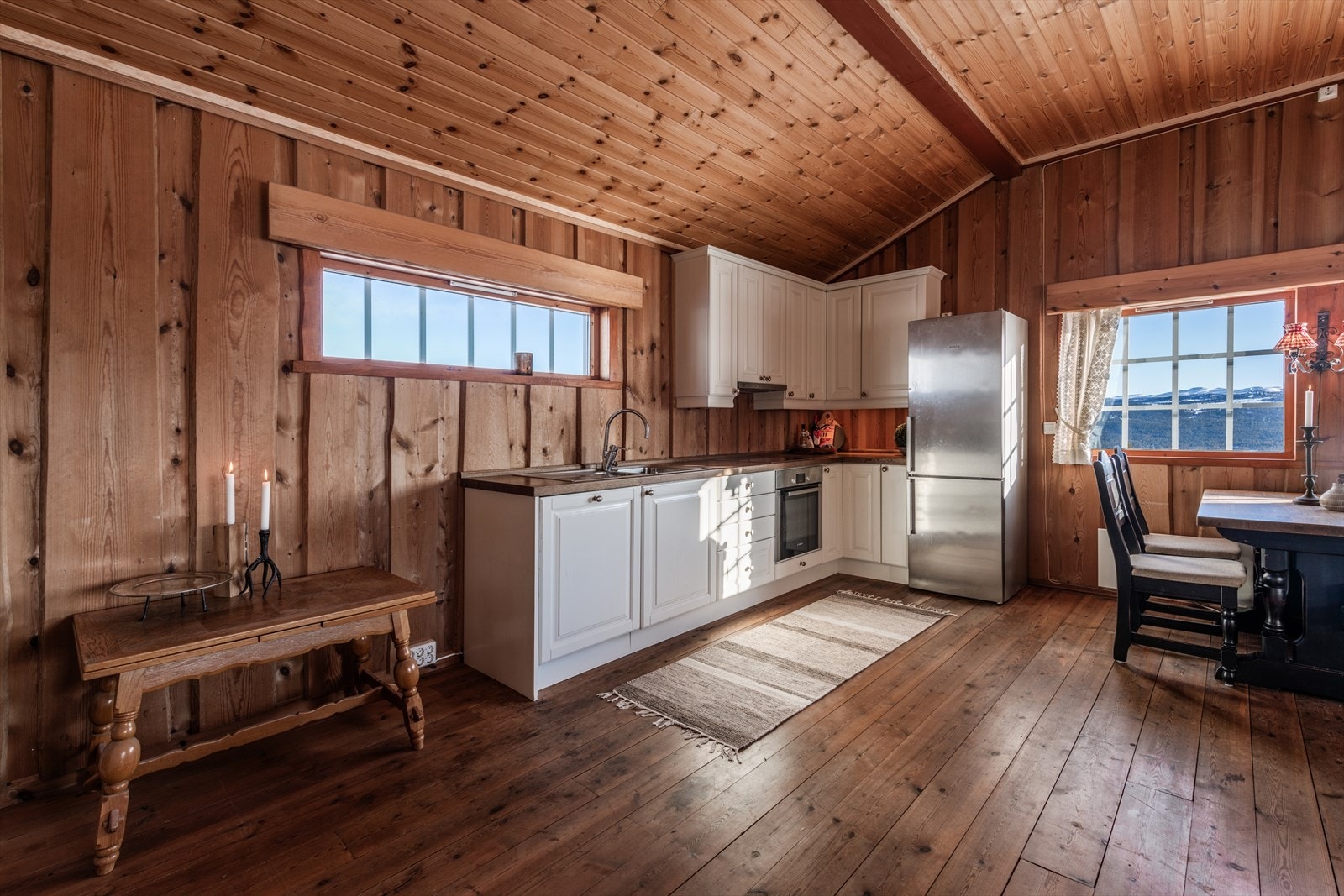 Kjøkkeninnredning i malt tre med under- og overskap med profilerte dører/fronter. Galleribilde