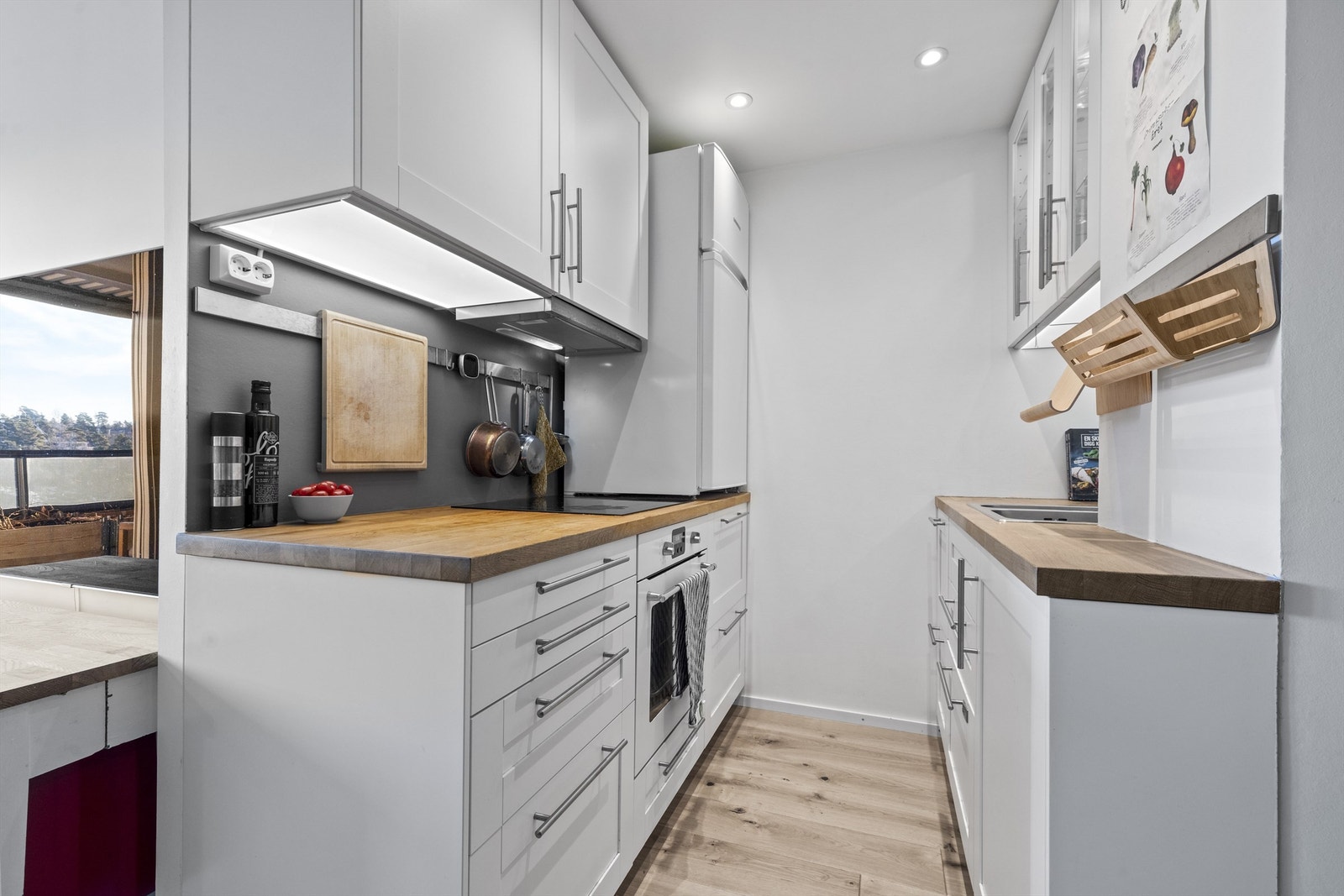 Kjøkkenet er innredet med blant annet profilerte fronter, benkeplate av tre og integrerte hvitevarer som nedfelt induksjonstopp, stekeovn og oppvaskmaskin. Galleribilde