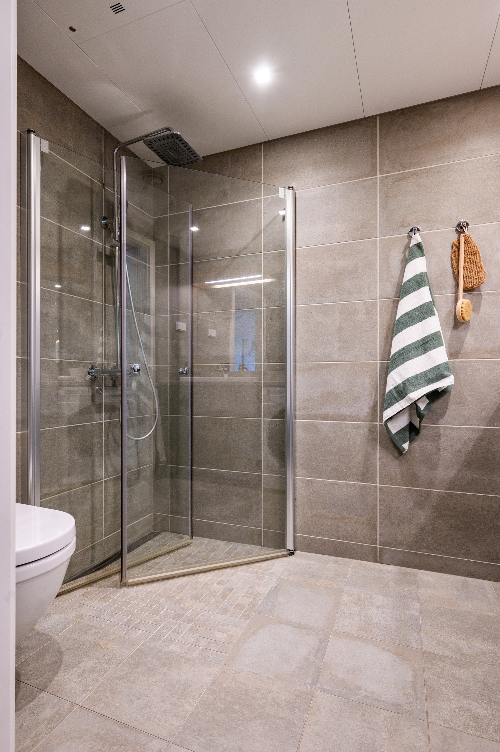 Dusjhjørne med svingbare glassdører, slukrenne, hånd- og regnfalldusj. Galleribilde