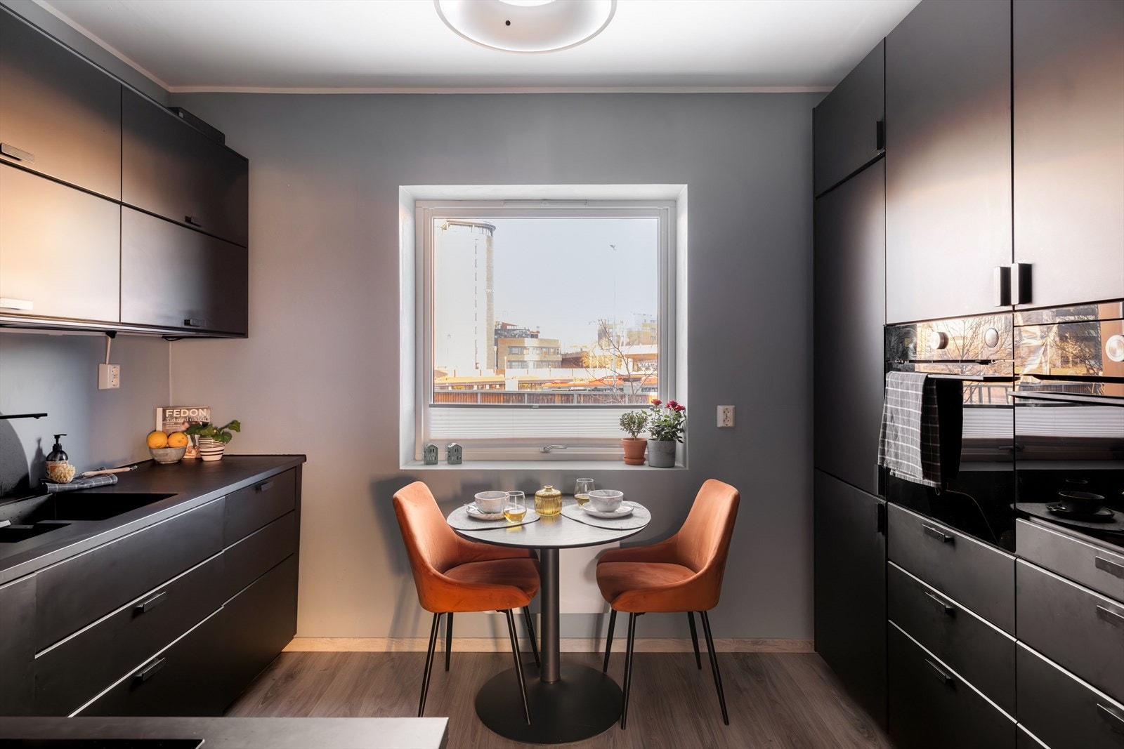 Kjøkkeninnredning med slette, mørke fronter og benkeplate av laminat med oppvaskkum med 1-greps blandebatteri Galleribilde