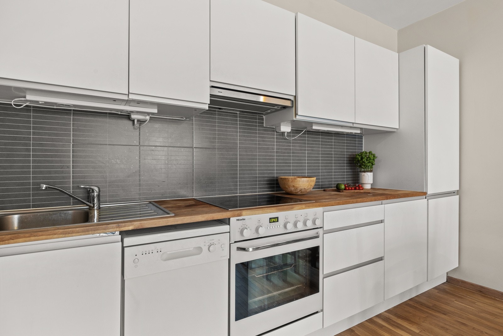 Fliser over benkeplate og to doble stikkontakter under overskap. Galleribilde