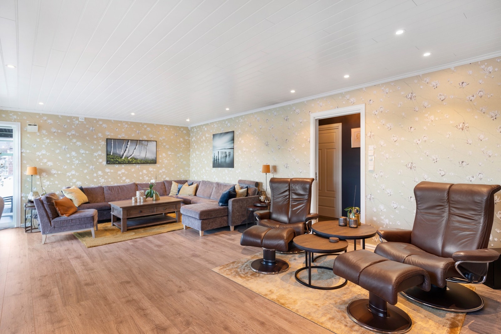 Stue har parkett på gulv, tapet på vegger og spotlights i himling. Galleribilde