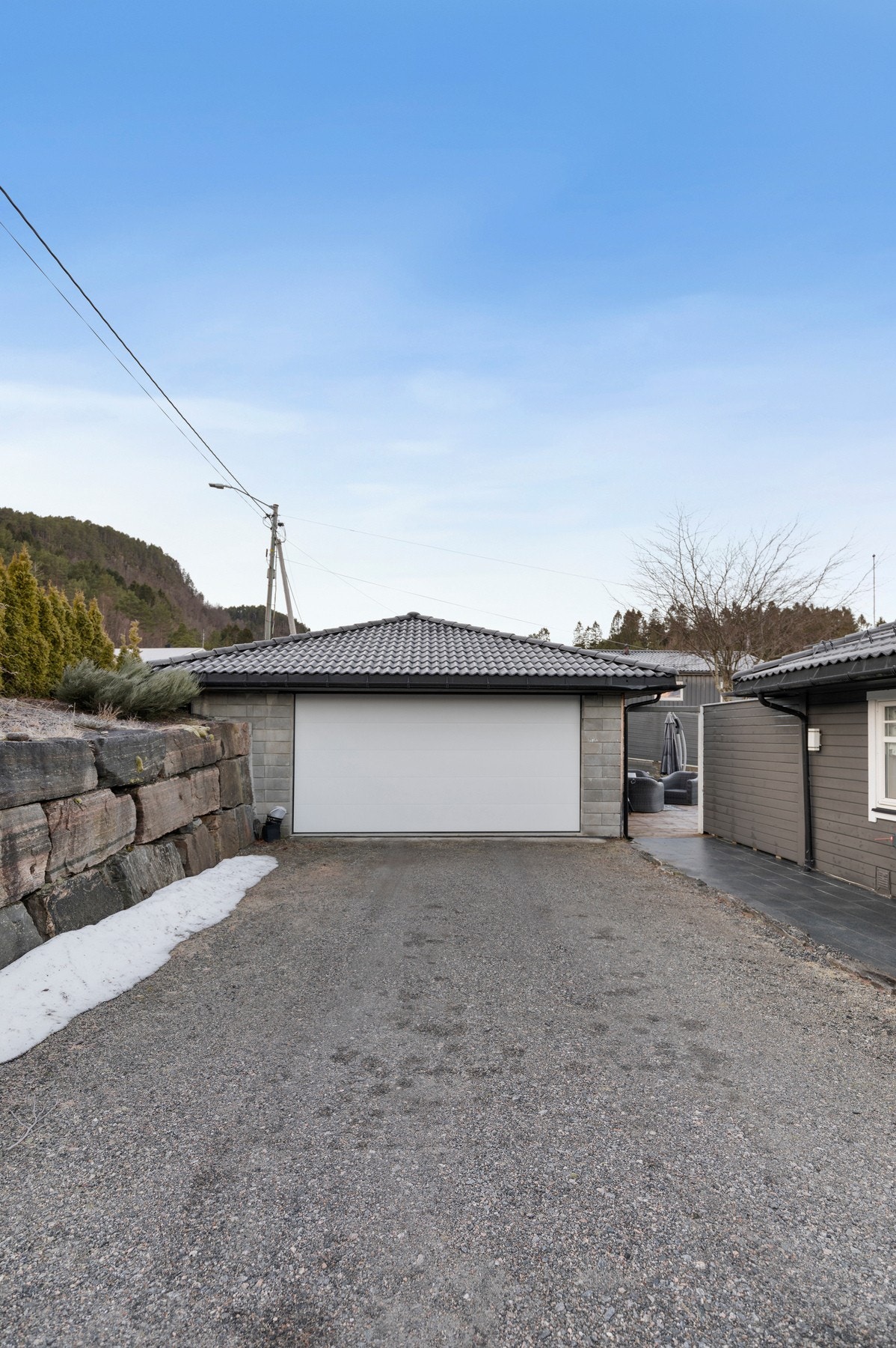 Garasjen har betongplate som gulv, garasjeport med motorisert åpning, opplegg for strøm og montert elbil-lader. Forøvrig biloppstillingsplasser på egen tomt. Galleribilde