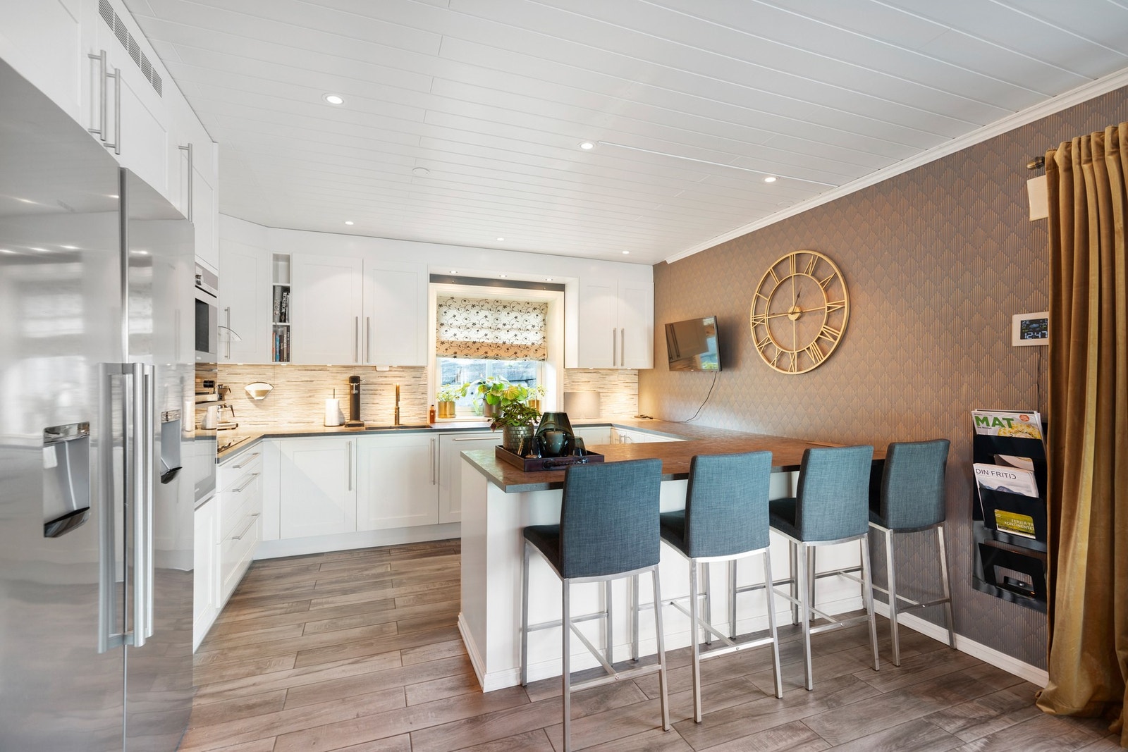 Kjøkkenet i hovedetasjen har innredning fra Drømmekjøkkenet i hvite, profilerte fronter. Galleribilde