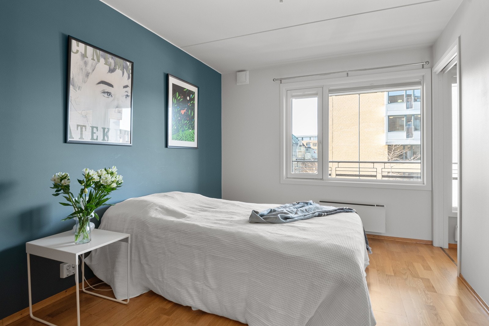 Soverommet har parkett på gulv, glatte lysmalte overflater med en fin blå kontrastvegg og skjult elektrisk anlegg. Stor vindusflate som vender ut mot balkongen. Galleribilde