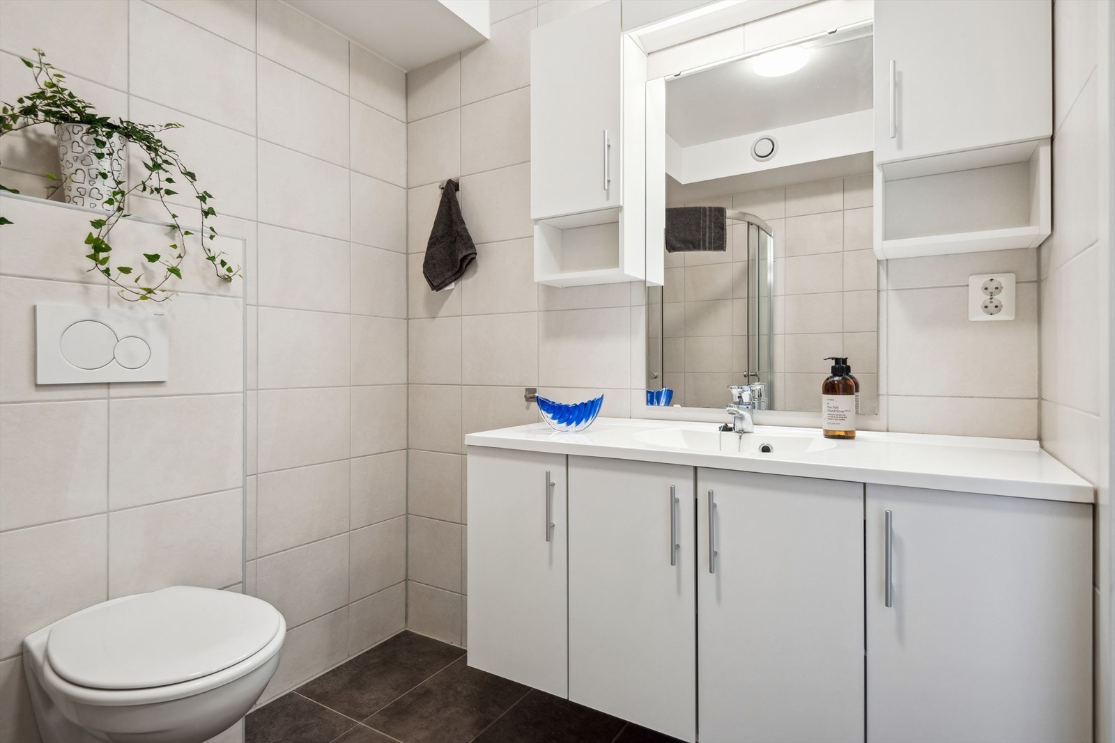 Badet er heilflisa og har har lyse overflater på vegger og tak, og varmekablar i golvet. Det er opplegg for vaskemaskin og tørketrommel i den innvendige boda. Galleribilde