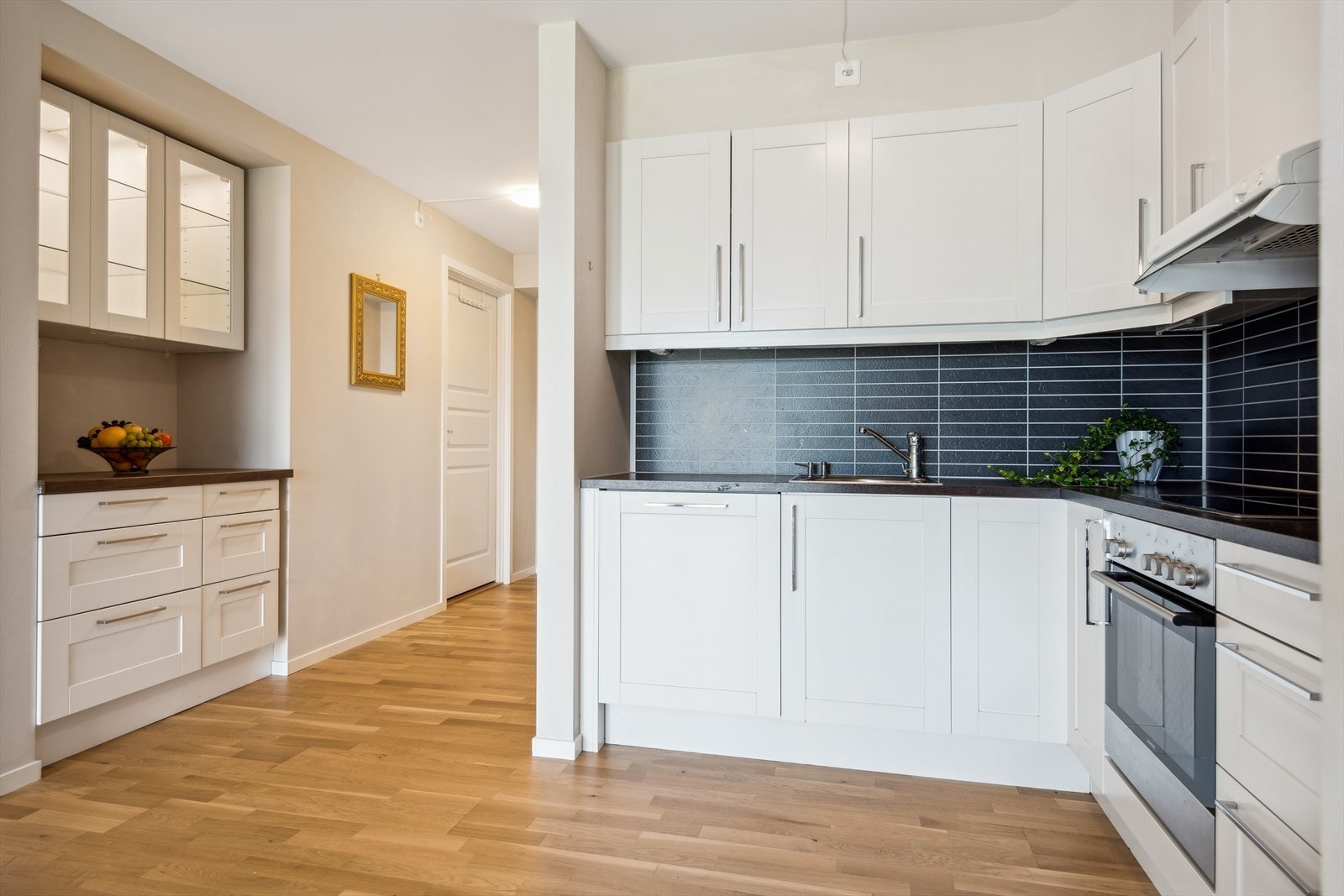 Det er lys i overskåpa med glasfrontar. Galleribilde