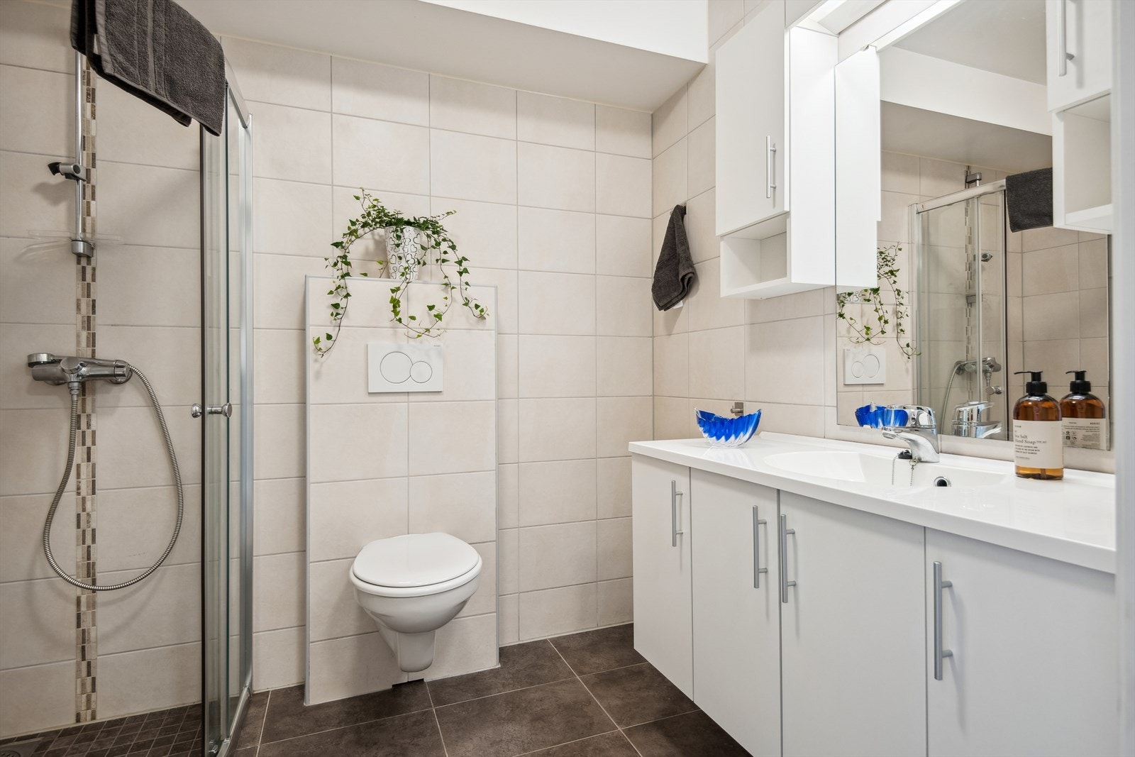 Badet er innreia med baderomsinnreiing med spegel, vegghengt toalett og dusjhjørna. Galleribilde