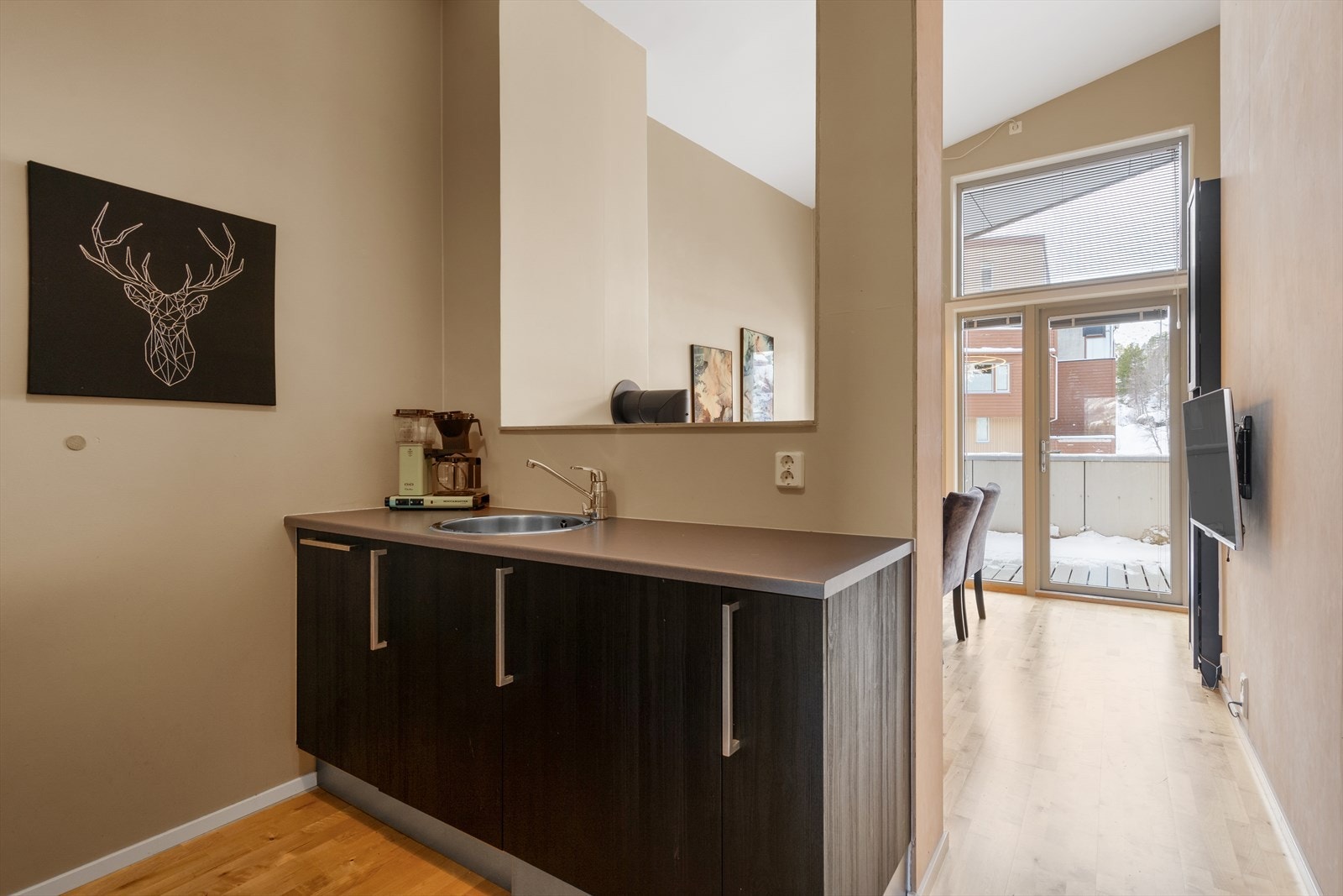 Kjøkkenet har tidløs innredning med slette fronter og benkeplate av laminat. Galleribilde