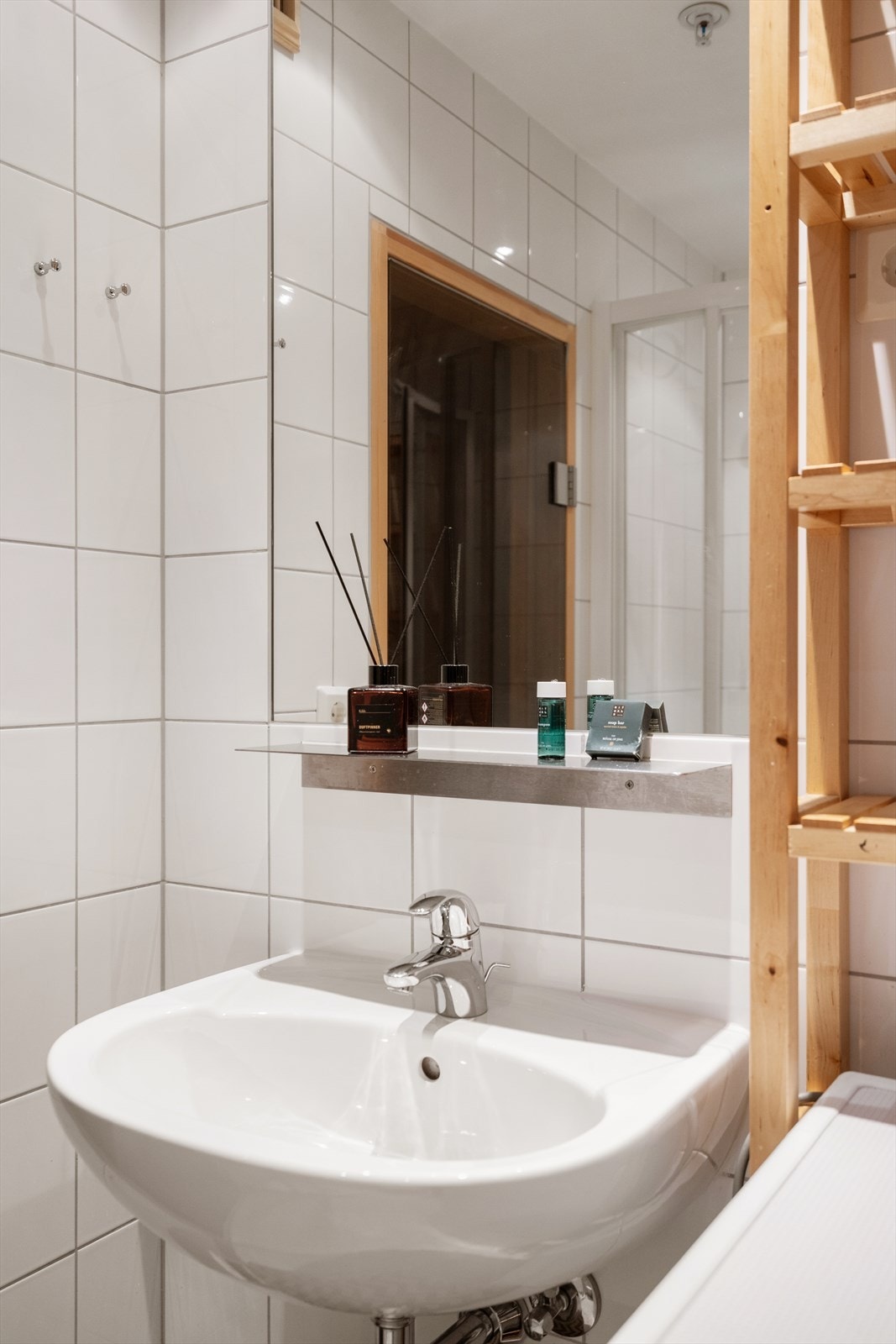 Badet er innredet med vegghengt toalett, servant, dusjhjørne og opplegg for vaskemaskin. Galleribilde