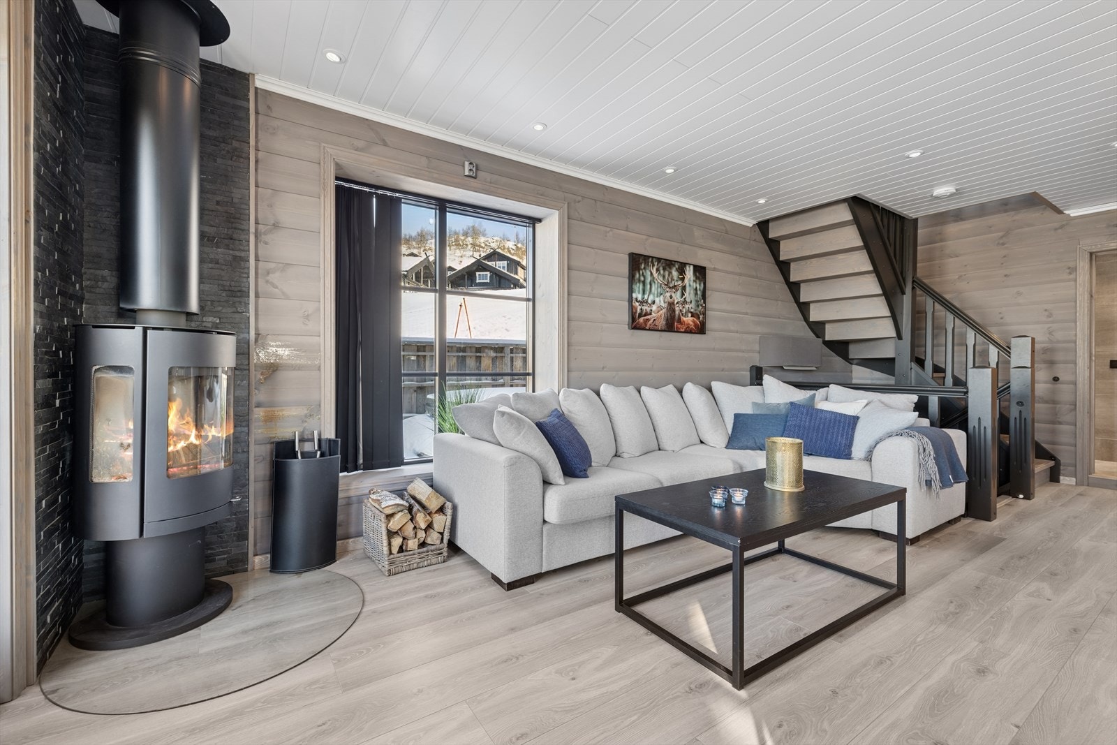 Stua er delikat innredet med tidsriktige farger, vedovn har glass på tre sider. Galleribilde