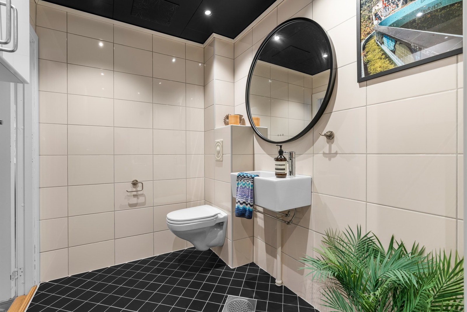 Det romslige badet har varmekabler i gulvet og er ellers innredet med et vegghengt toalett, en dusjnisje med innfellbare glassdører og opplegg for vaskemaskin. Galleribilde
