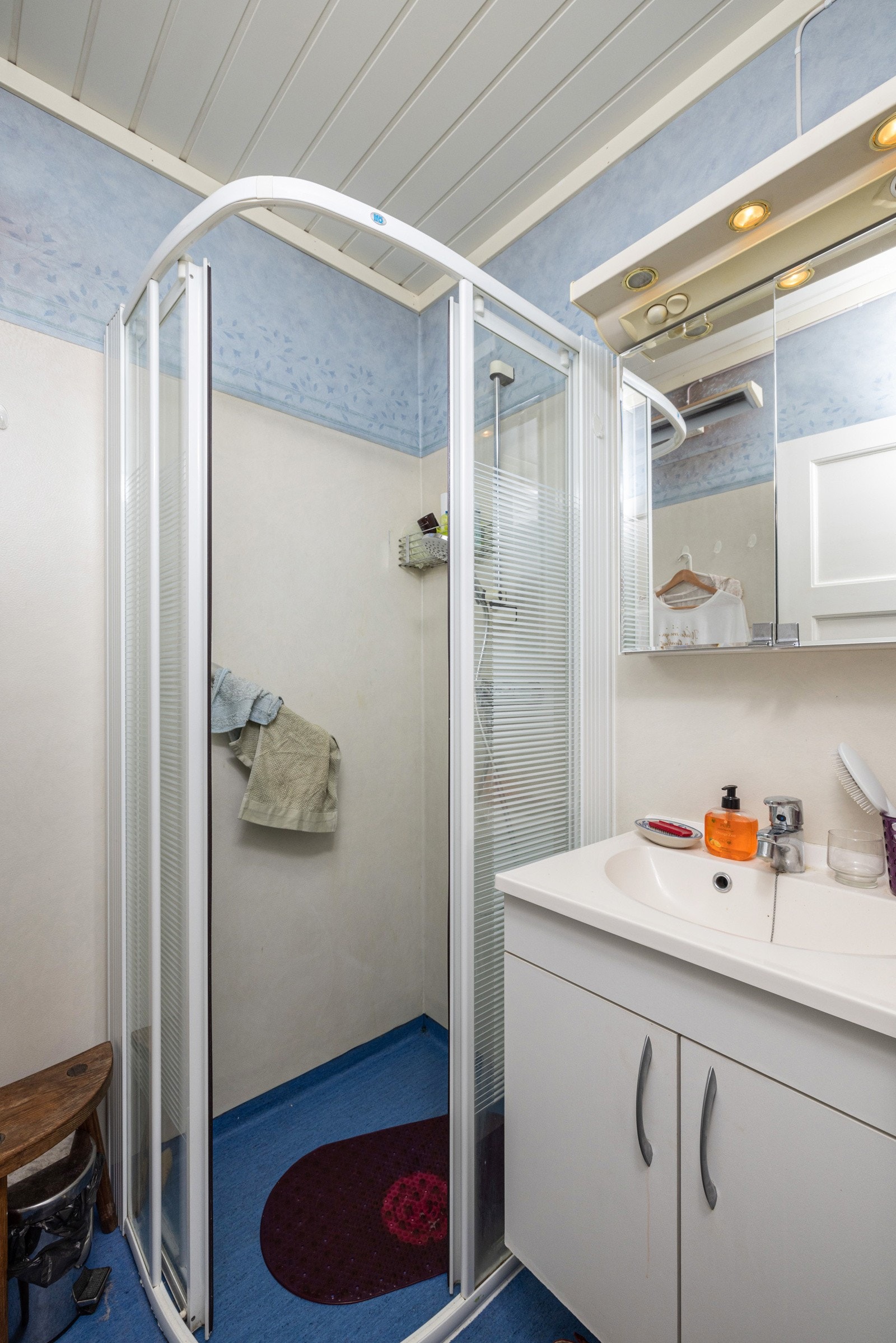 Bad i 1.etasje innredet med servant på innredning og dusjhjørne med skyvedør. Galleribilde