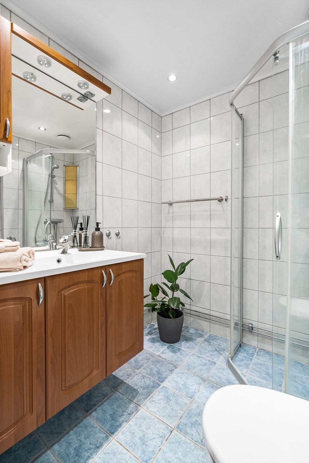 Badet er innredet med klosett, servant med innredning og dusjhjørne med skyvbar glassdør. Det er rikelig med oppbevaring i flere skap. Galleribilde