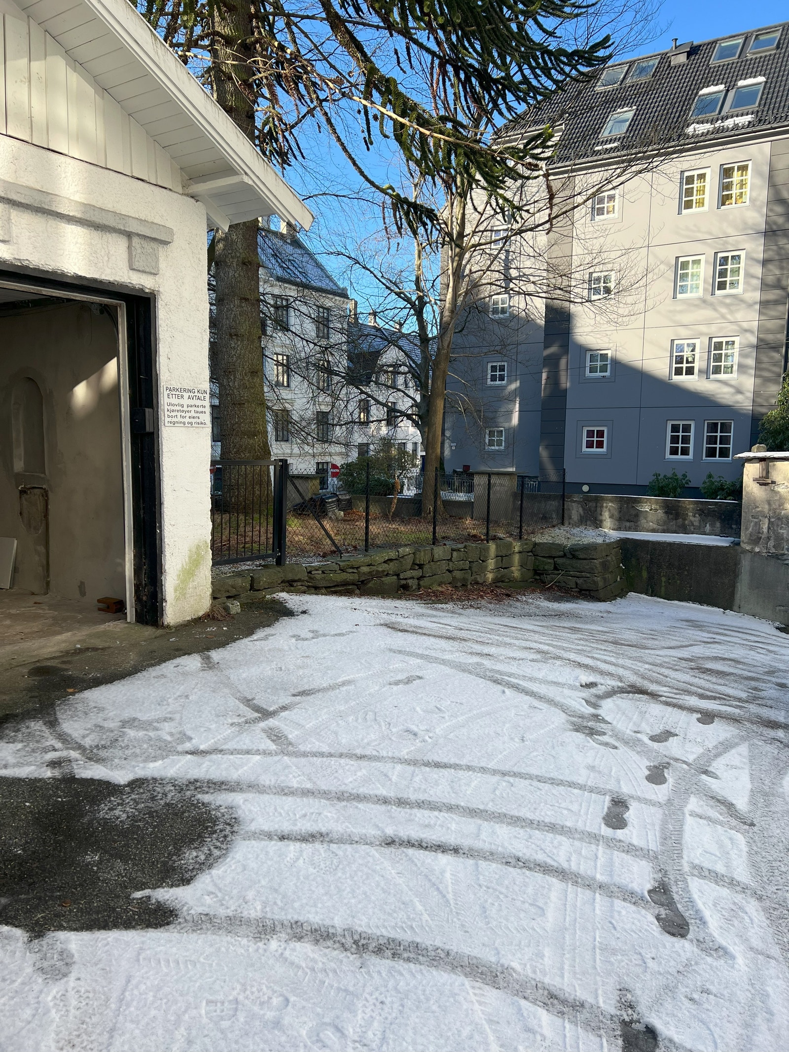 Garasjen befinner seg på en større parkeringsplass tilknyttet eiendom som strøs ved glatte forhold. Galleribilde