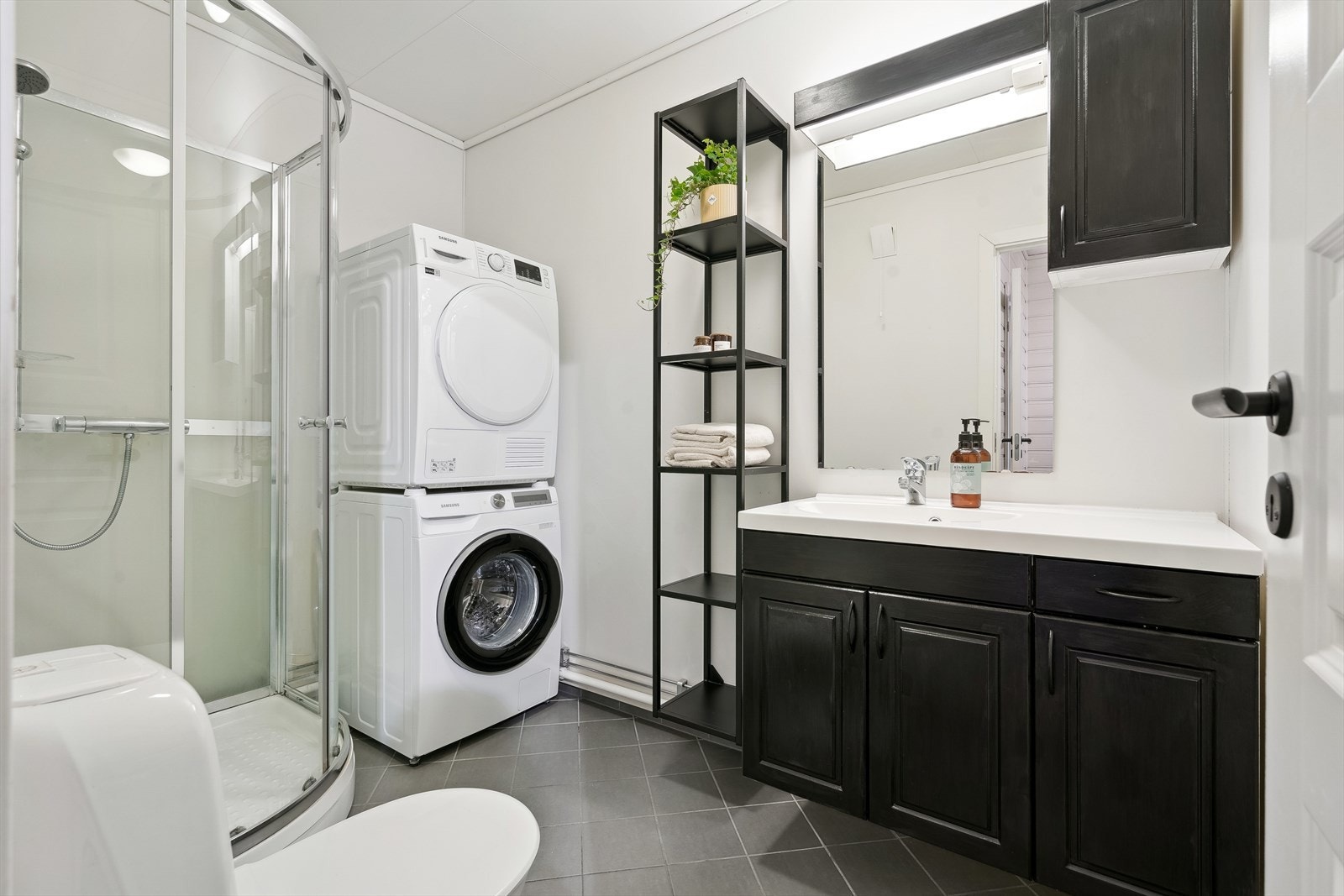 Badet, oppgradert i 2010, er utstyrt med gulvfliser, våtromsplater på veggene, dusjkabinett, toalett, servant med skapinnredning og opplegg for vaskemaskin. Varmekabler i gulv. Galleribilde